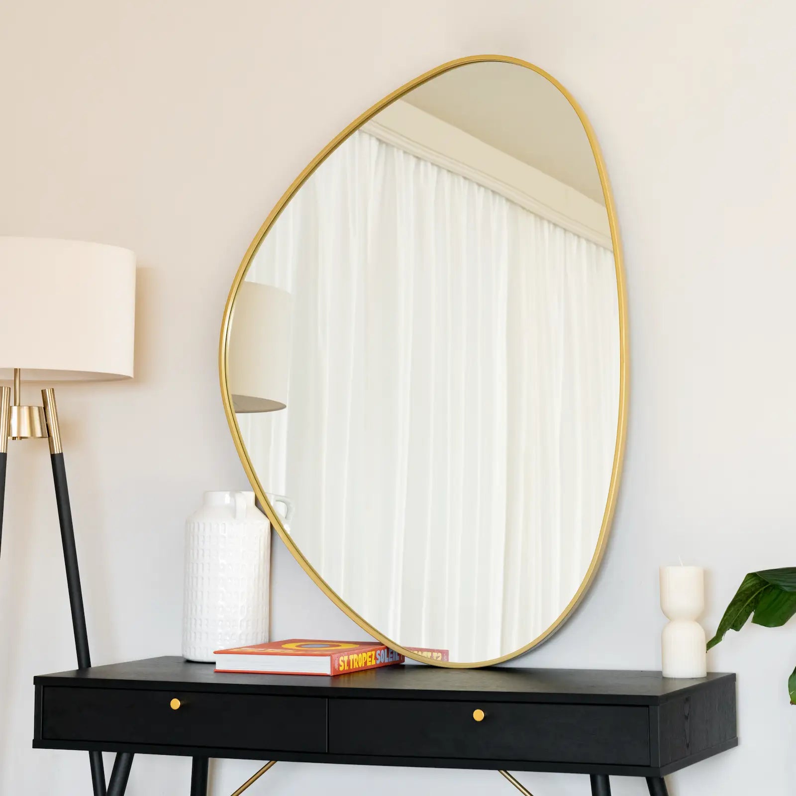 Oval mirror with a thin gold frame.