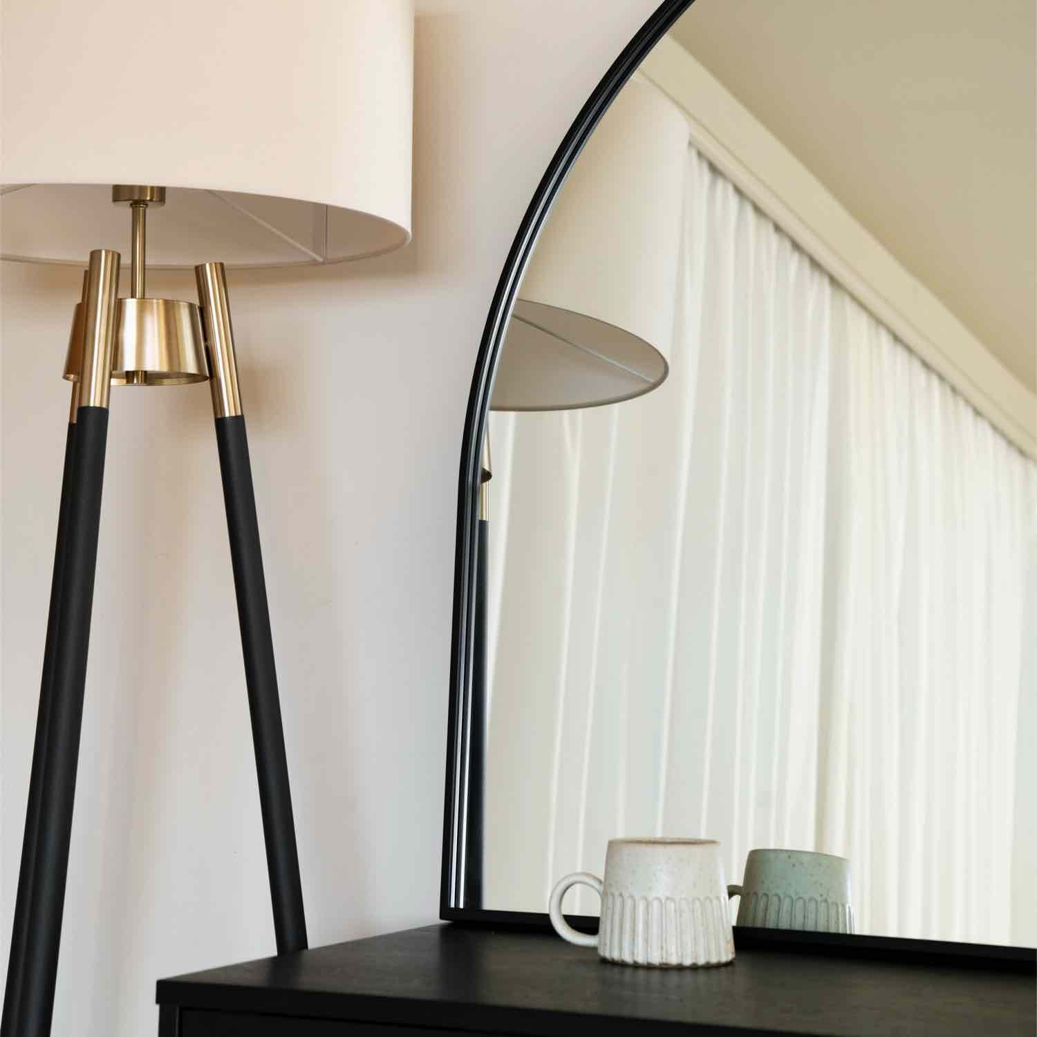 Modern tripod floor lamp with black legs and gold metallic accents.