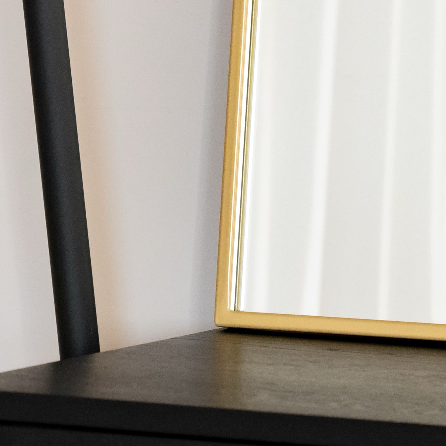 Black table with a partial gold-framed mirror visible.