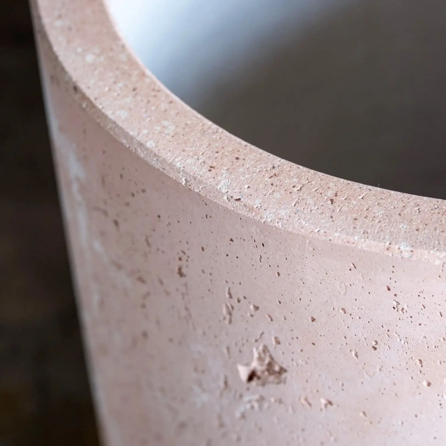 Textured, light-pink, cylindrical container.