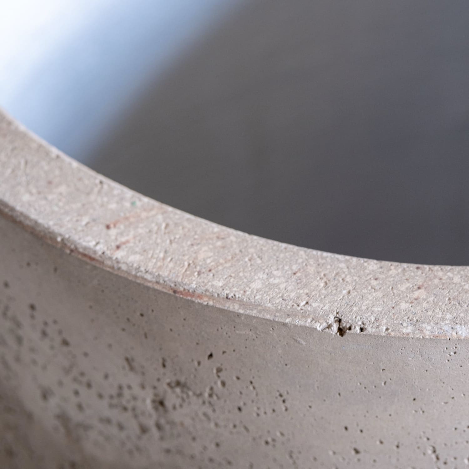 Textured gray concrete pot rim.