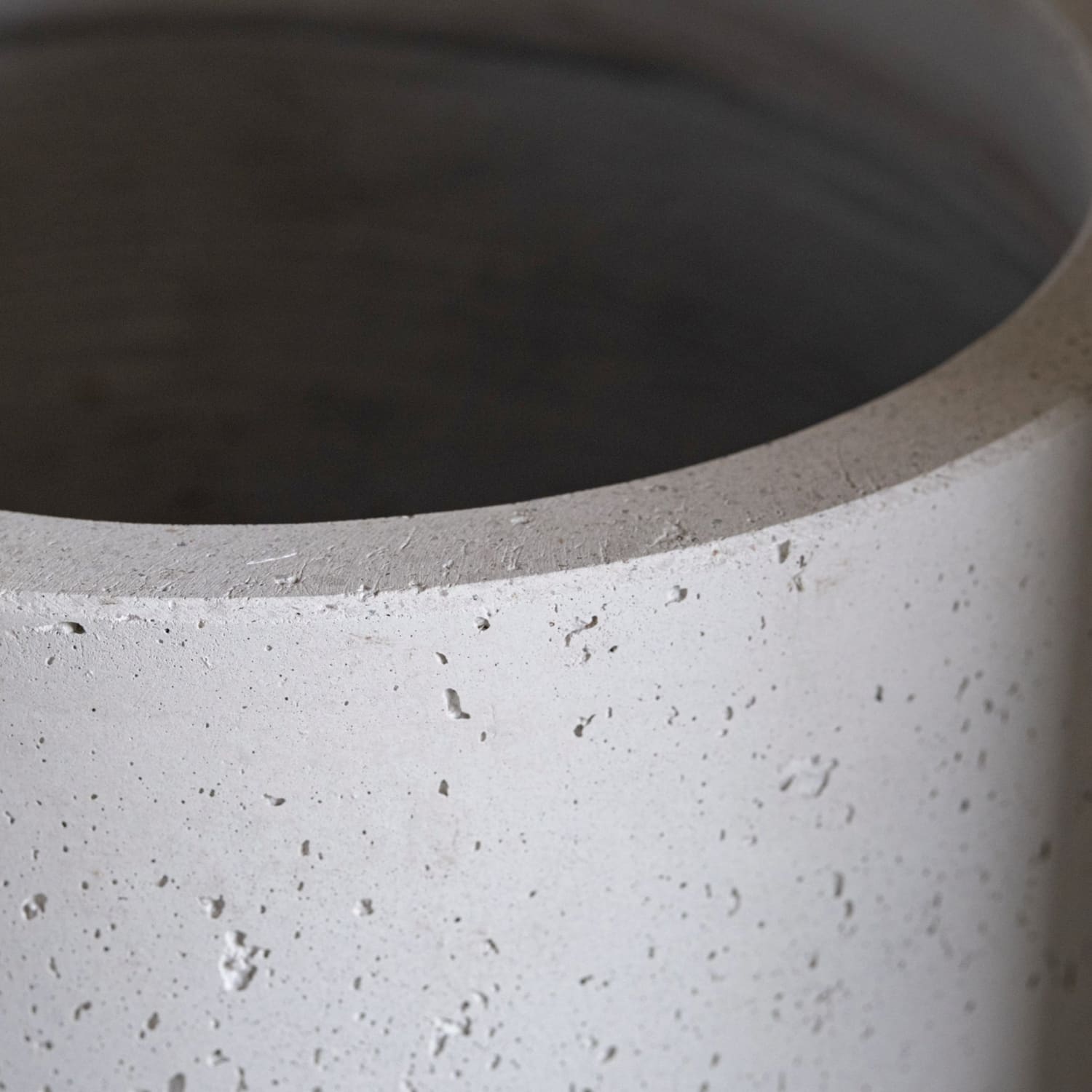 Porous gray concrete cylinder.