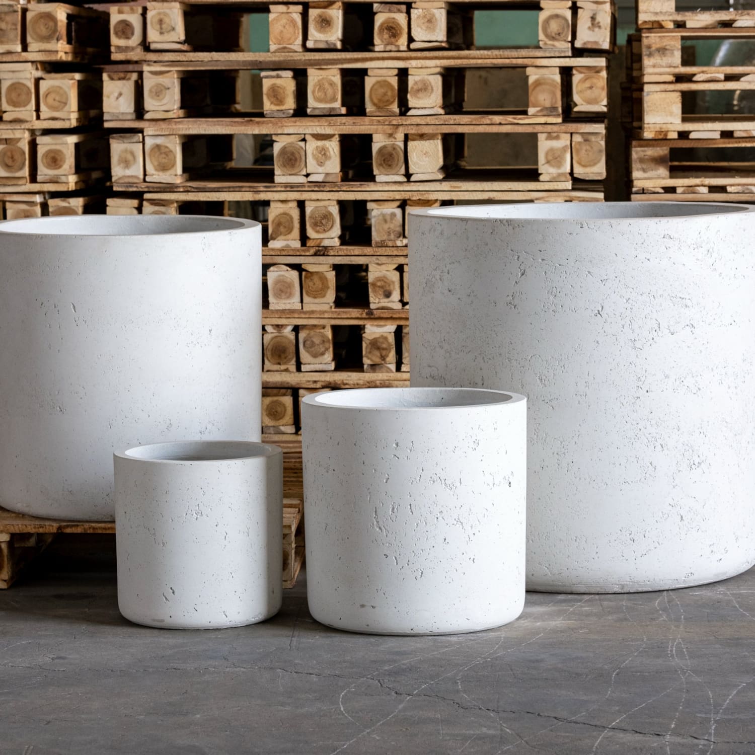Four white cylindrical planters.