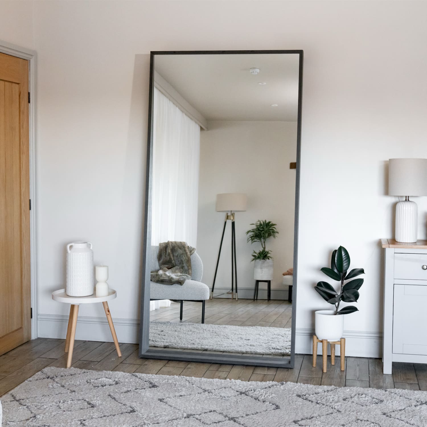 Floor-length mirror with a black metal frame.