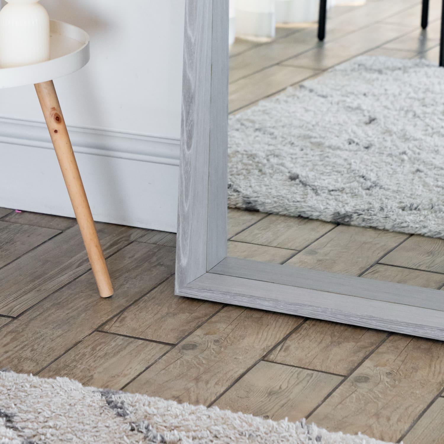 Gray-framed floor mirror with wooden legs.