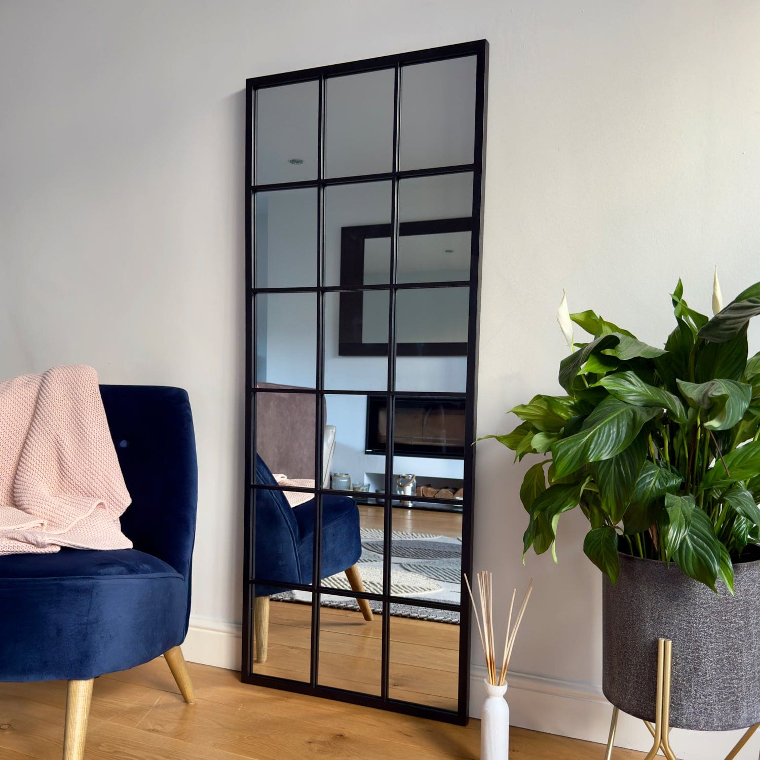 Black-framed geometric paneled mirror with a modern grid design.