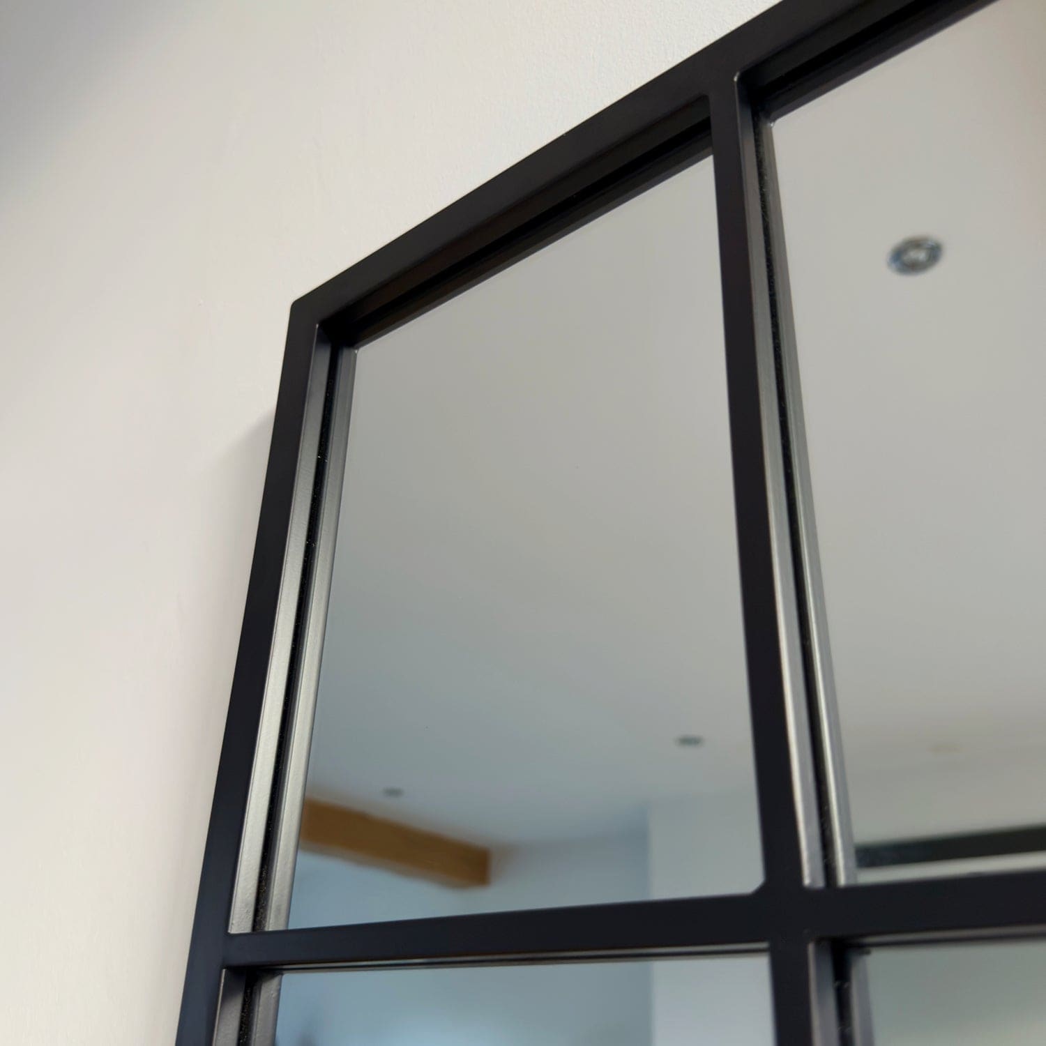 Black-framed window-style mirror with grid pattern.