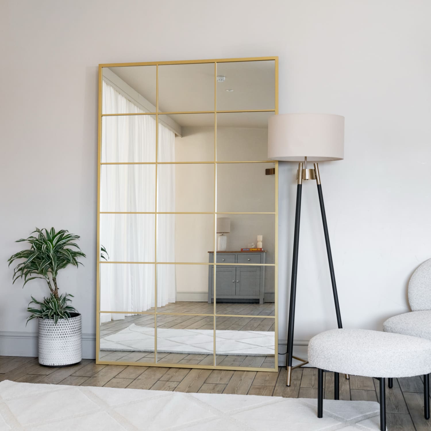 Gold-framed paneled mirror with a grid pattern.