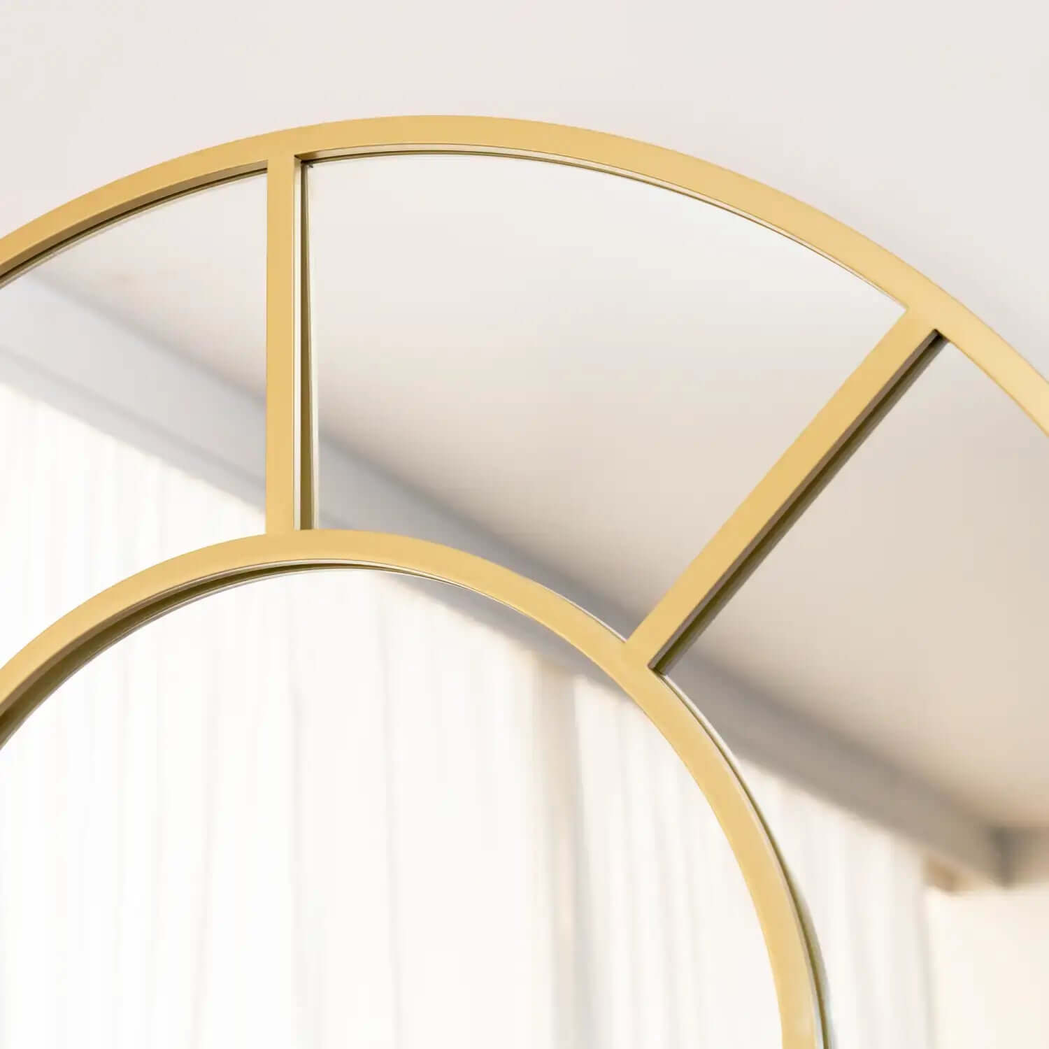 Gold-framed circular wall mirror with geometric dividing lines.