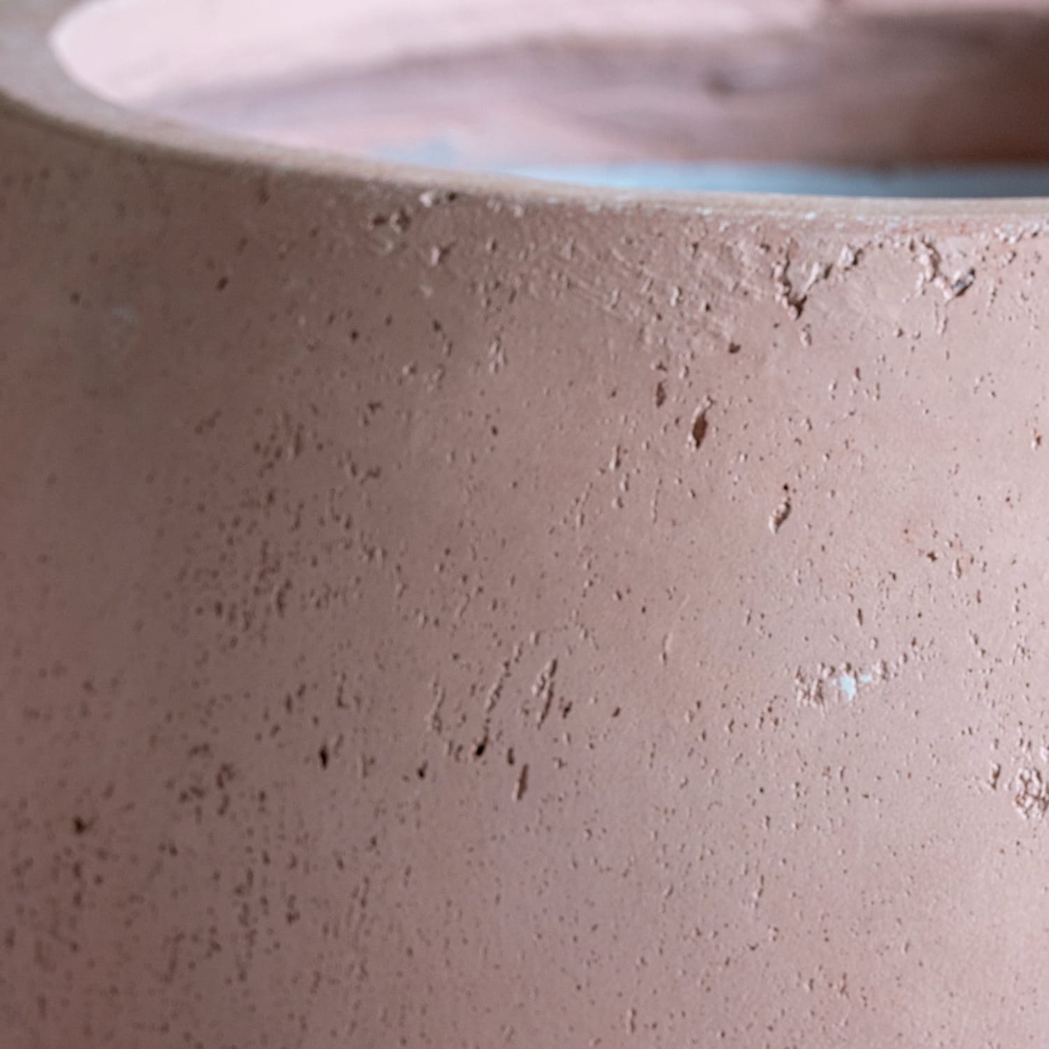 Rough, pinkish-tan concrete planter.