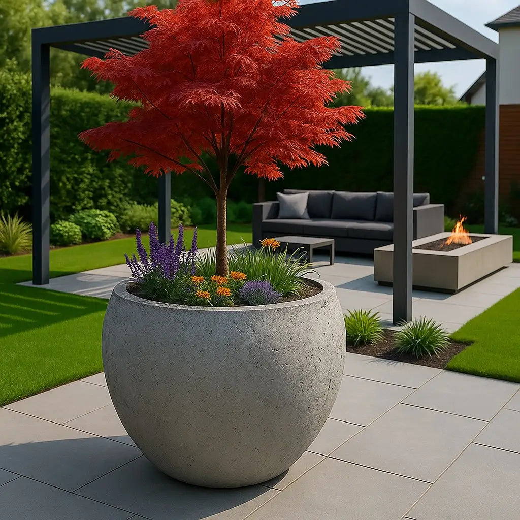 Round concrete planter with red tree.