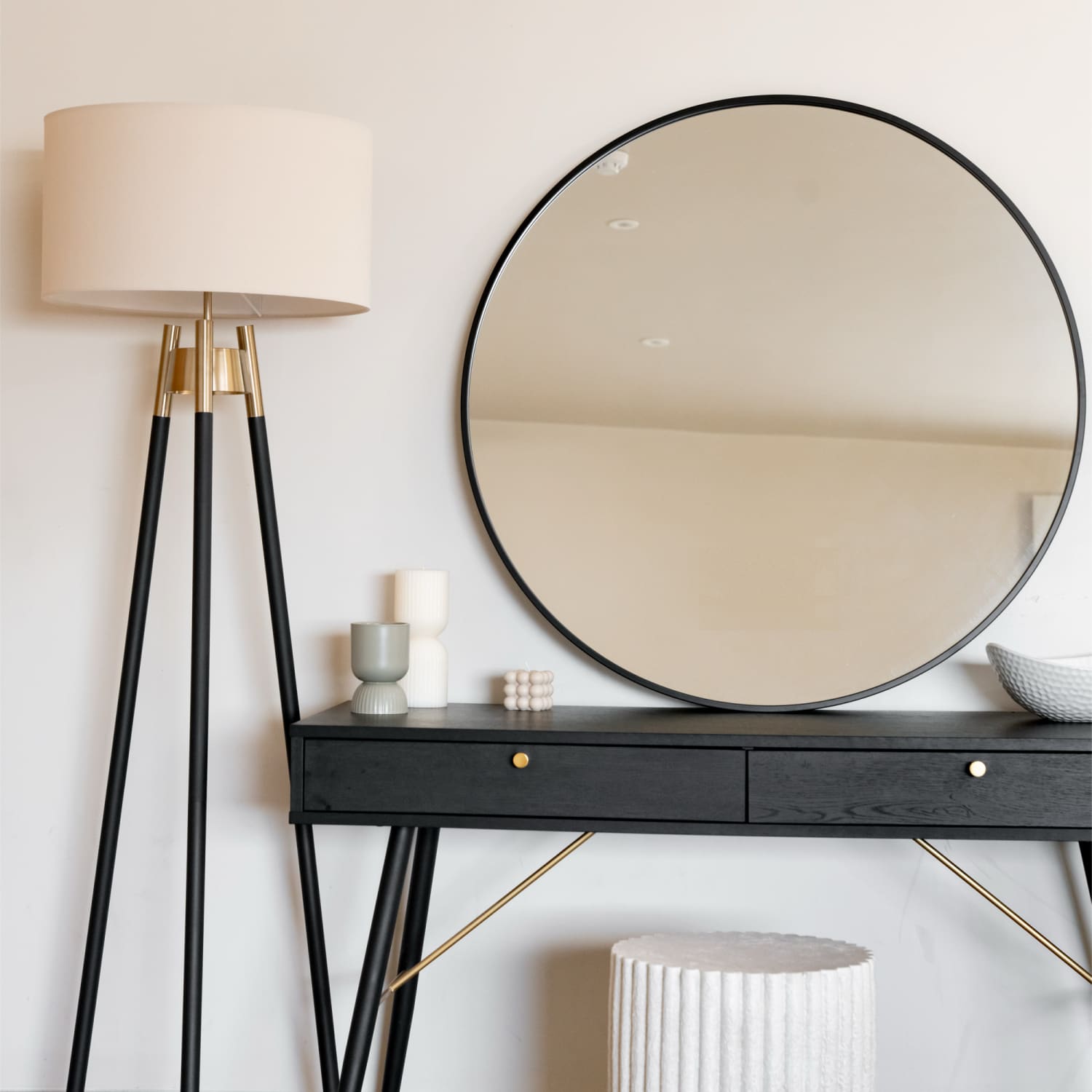 Round mirror with a thin black metal frame.