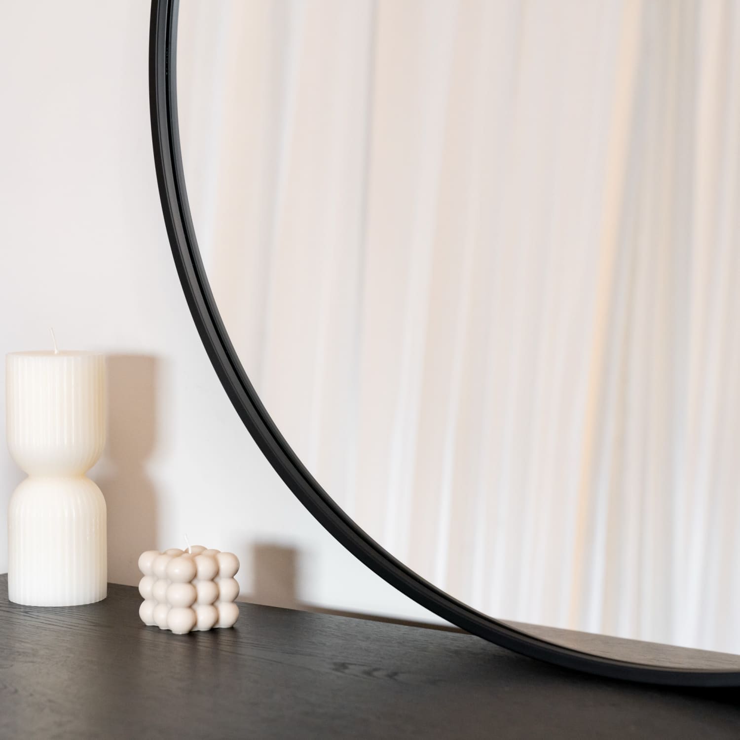 Black framed circular mirror.