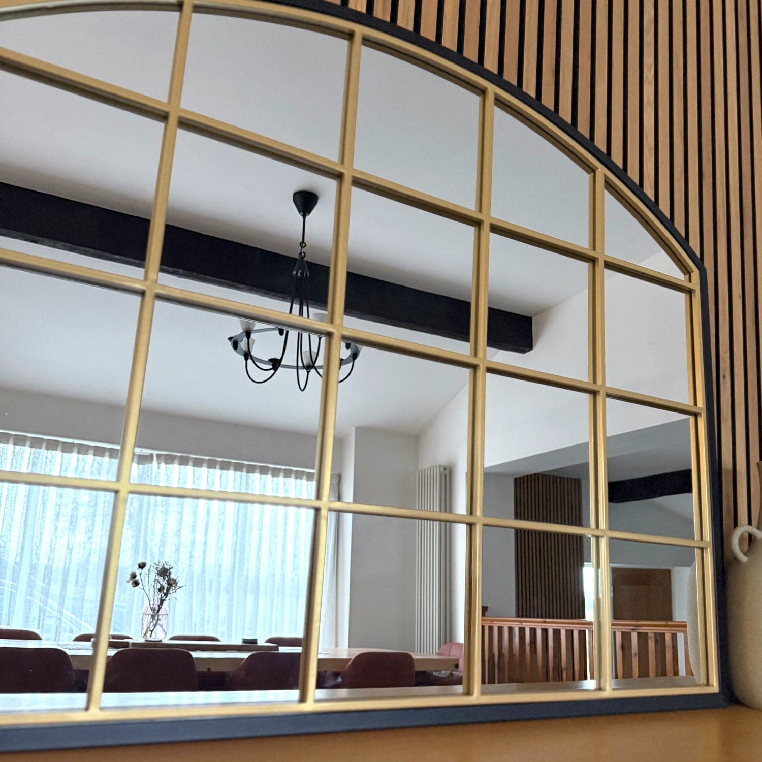 Arched window frame with gold-colored metal dividers