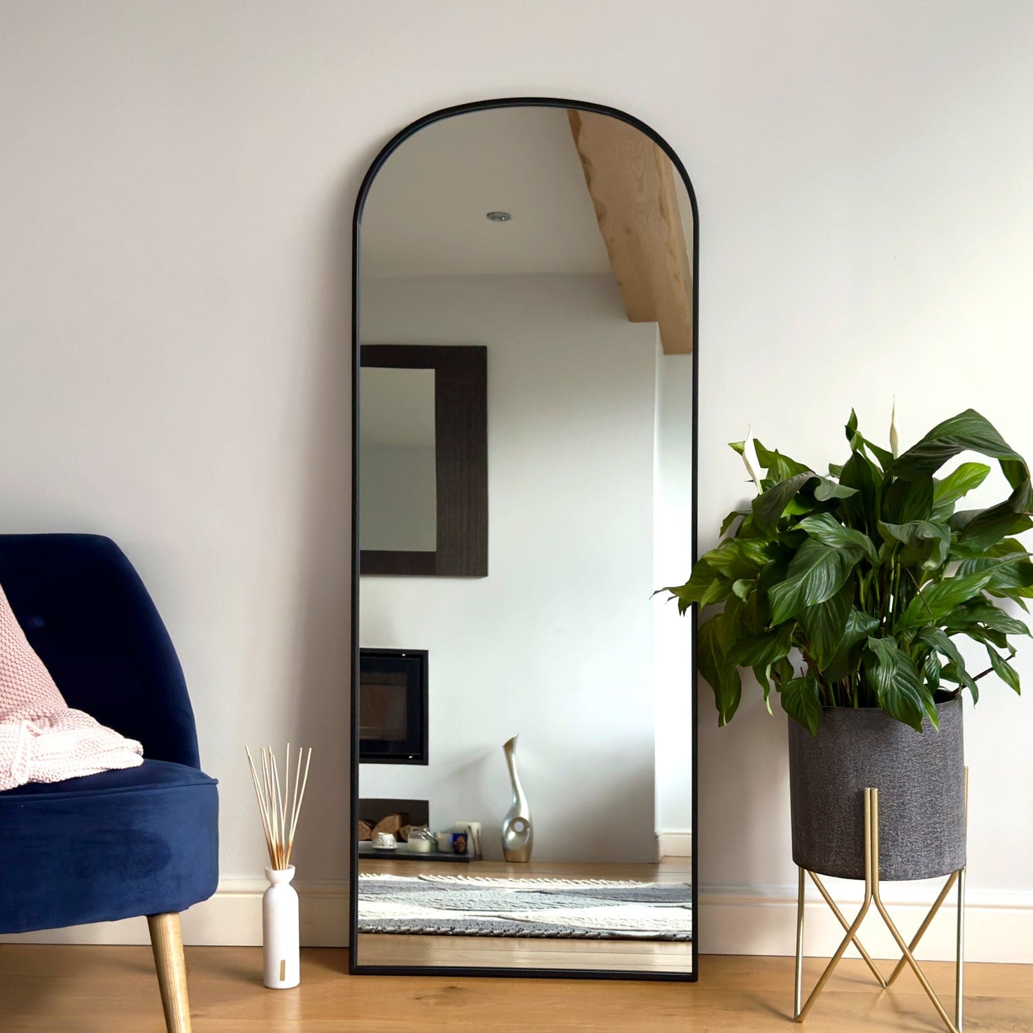 Arched floor mirror with a black metal frame.