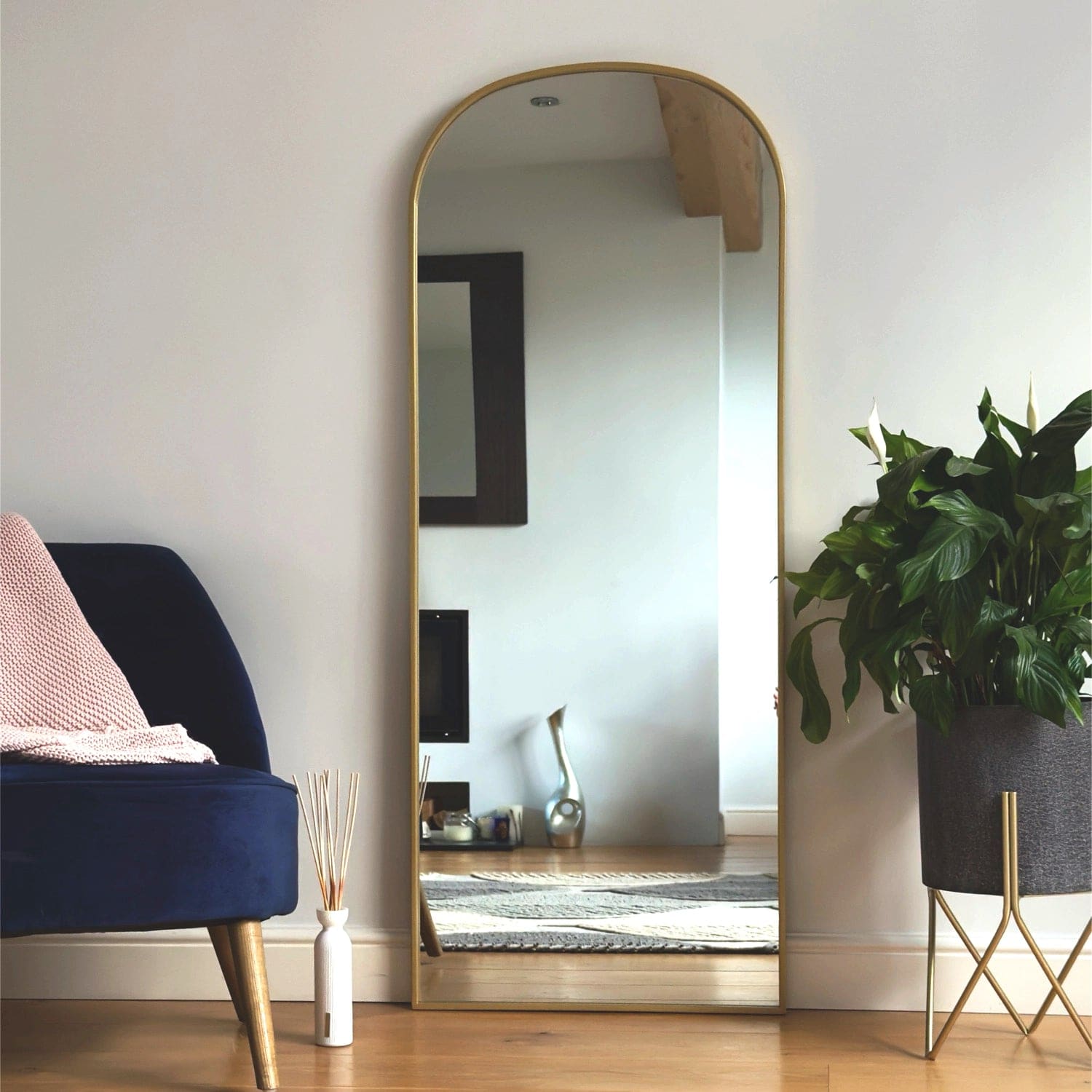 Gold-framed arched mirror.