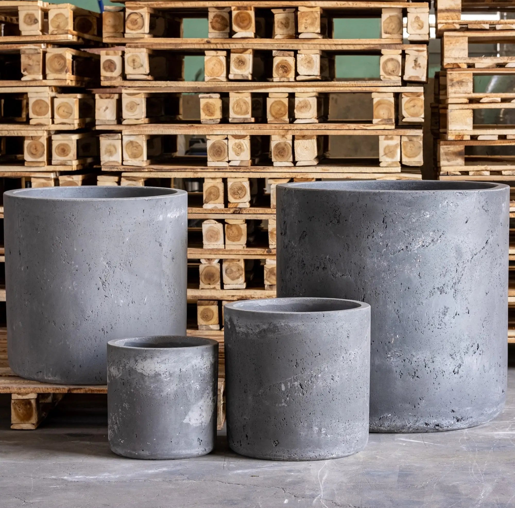 Four gray concrete cylindrical planters.
