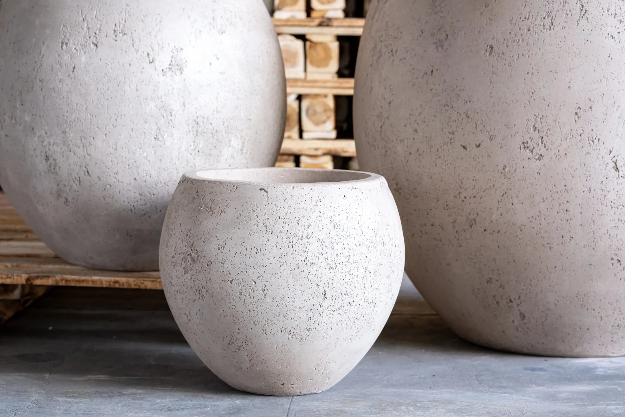 Three textured, light-colored, spherical planters.