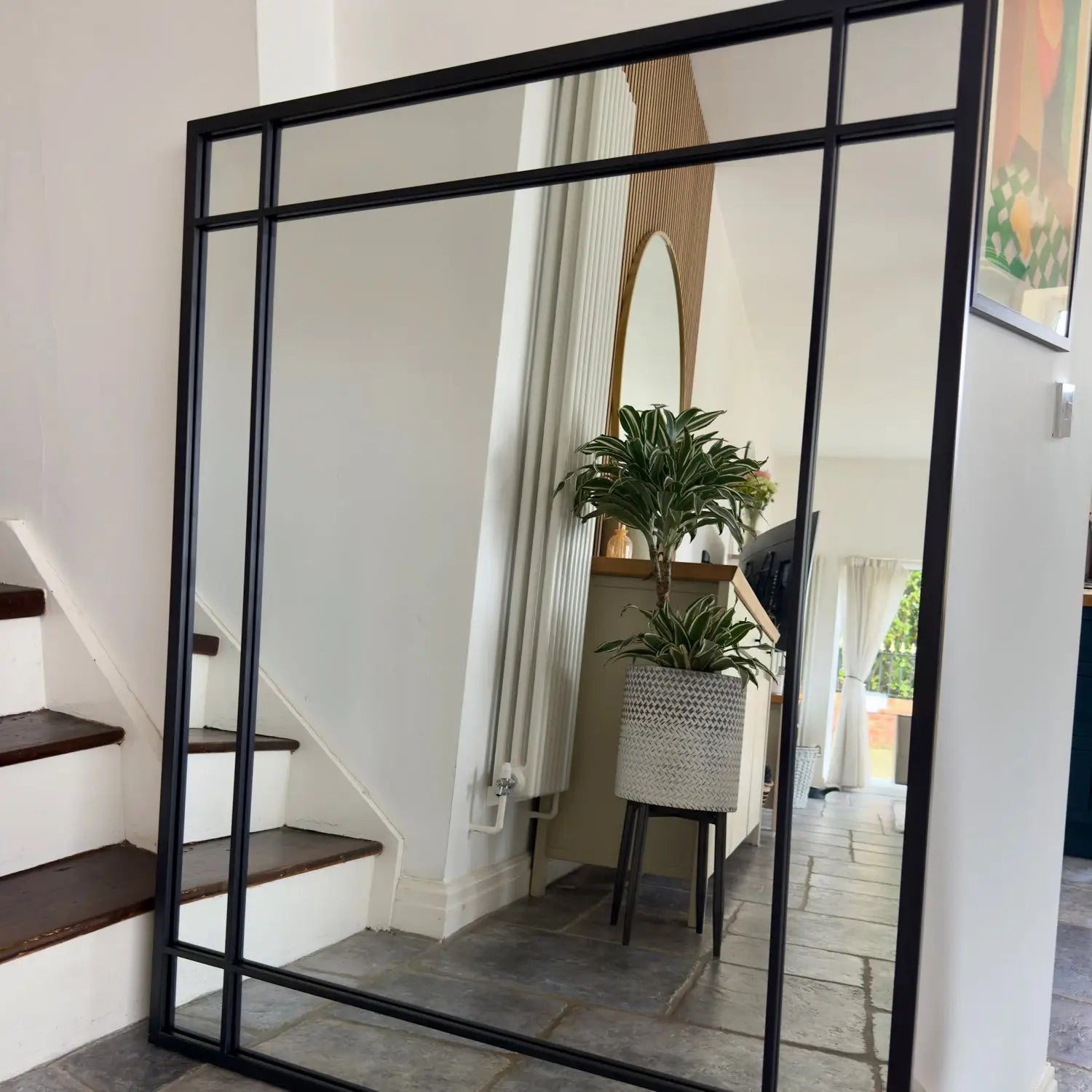 Black-framed geometric mirror with grid pattern.