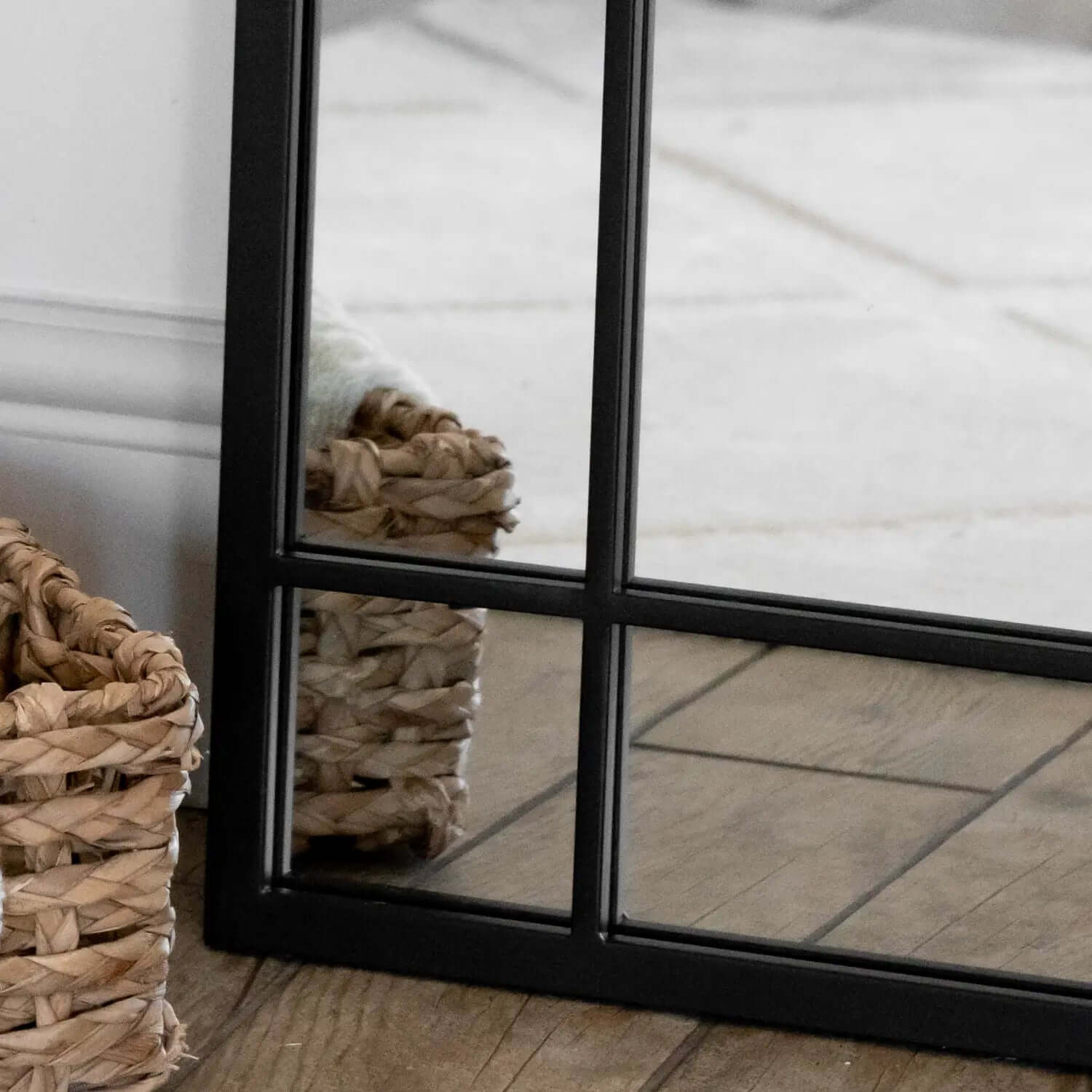 Black-framed window pane mirror with grid pattern.