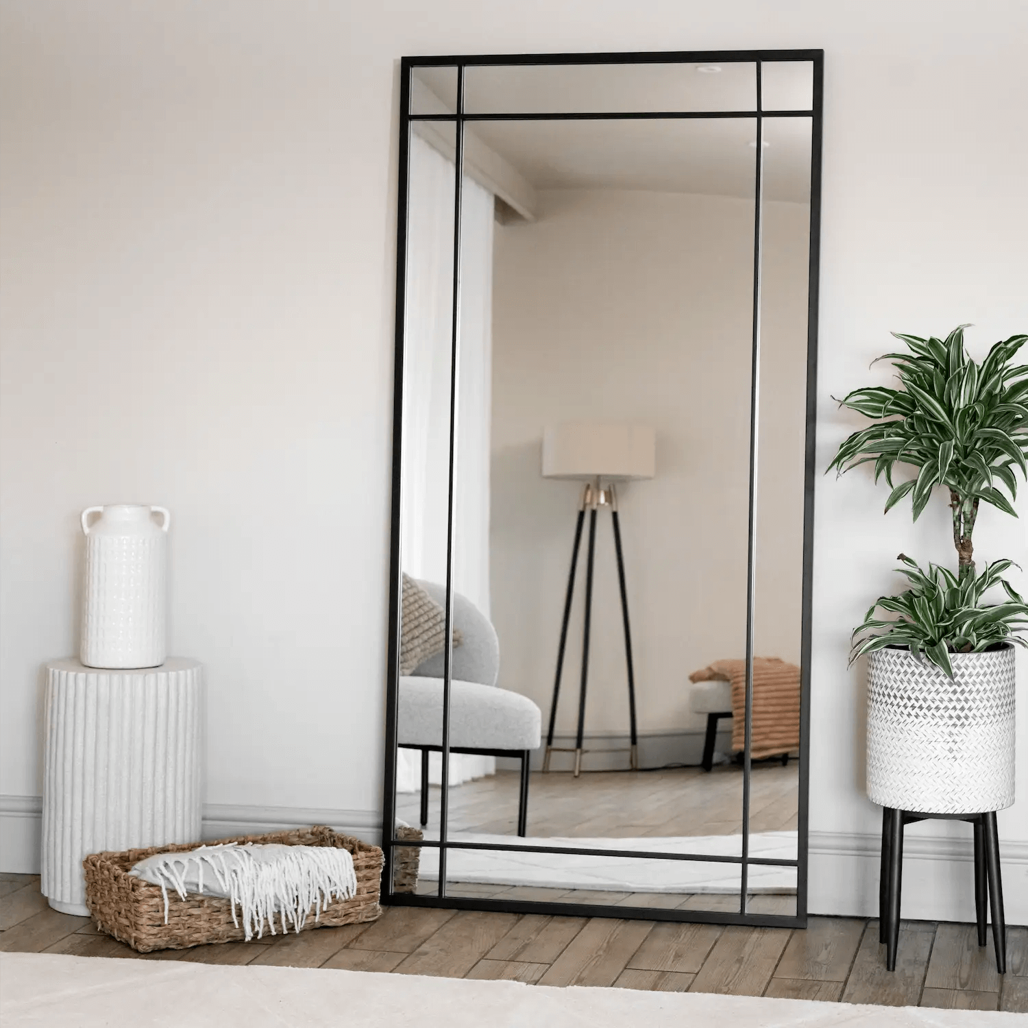 Black-framed floor mirror with geometric border design.