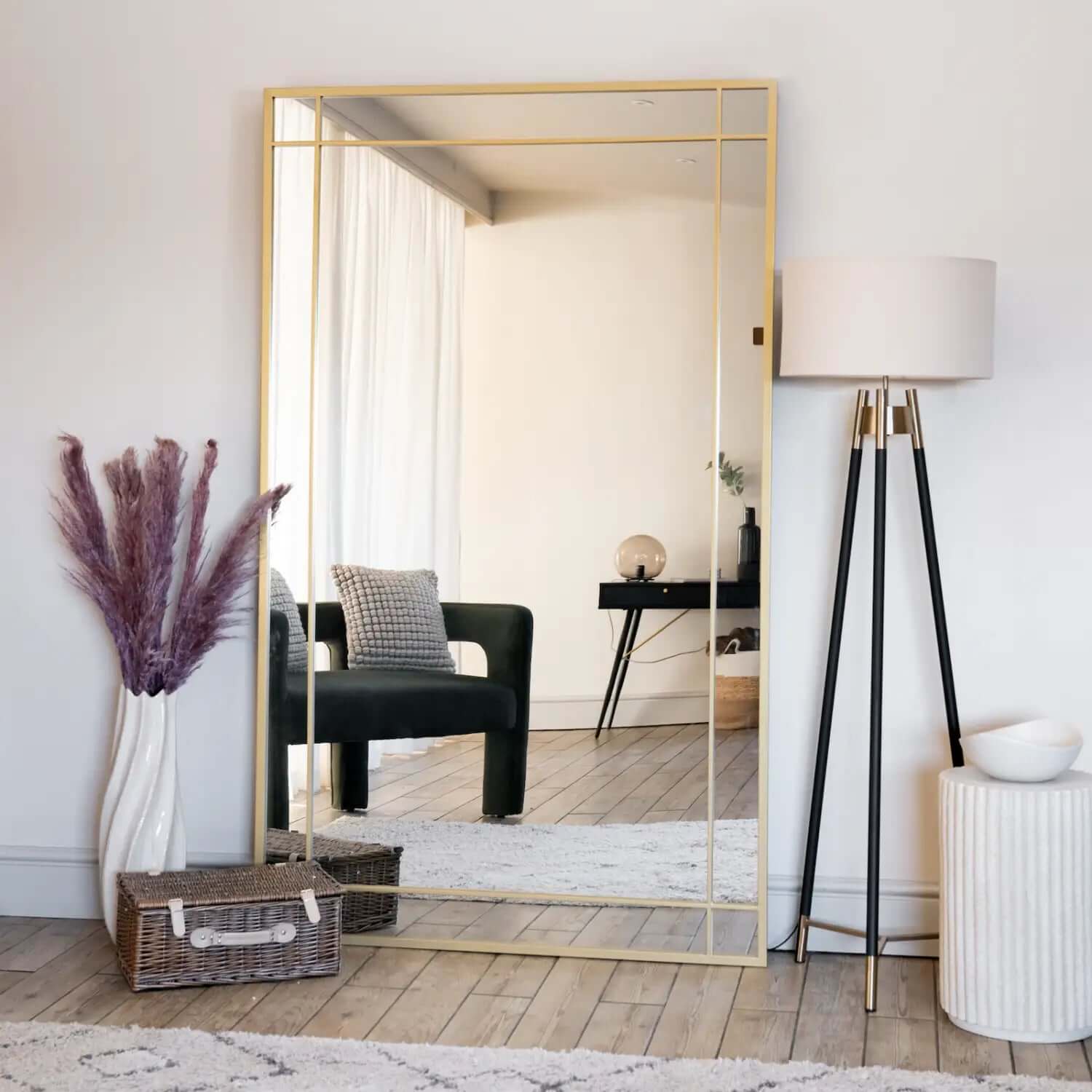 Gold-framed floor mirror with geometric border details.