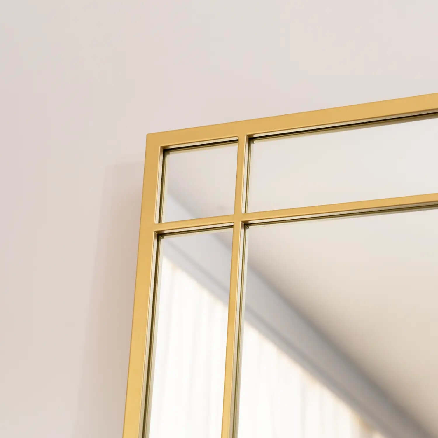 Gold-framed mirror with geometric grid pattern.