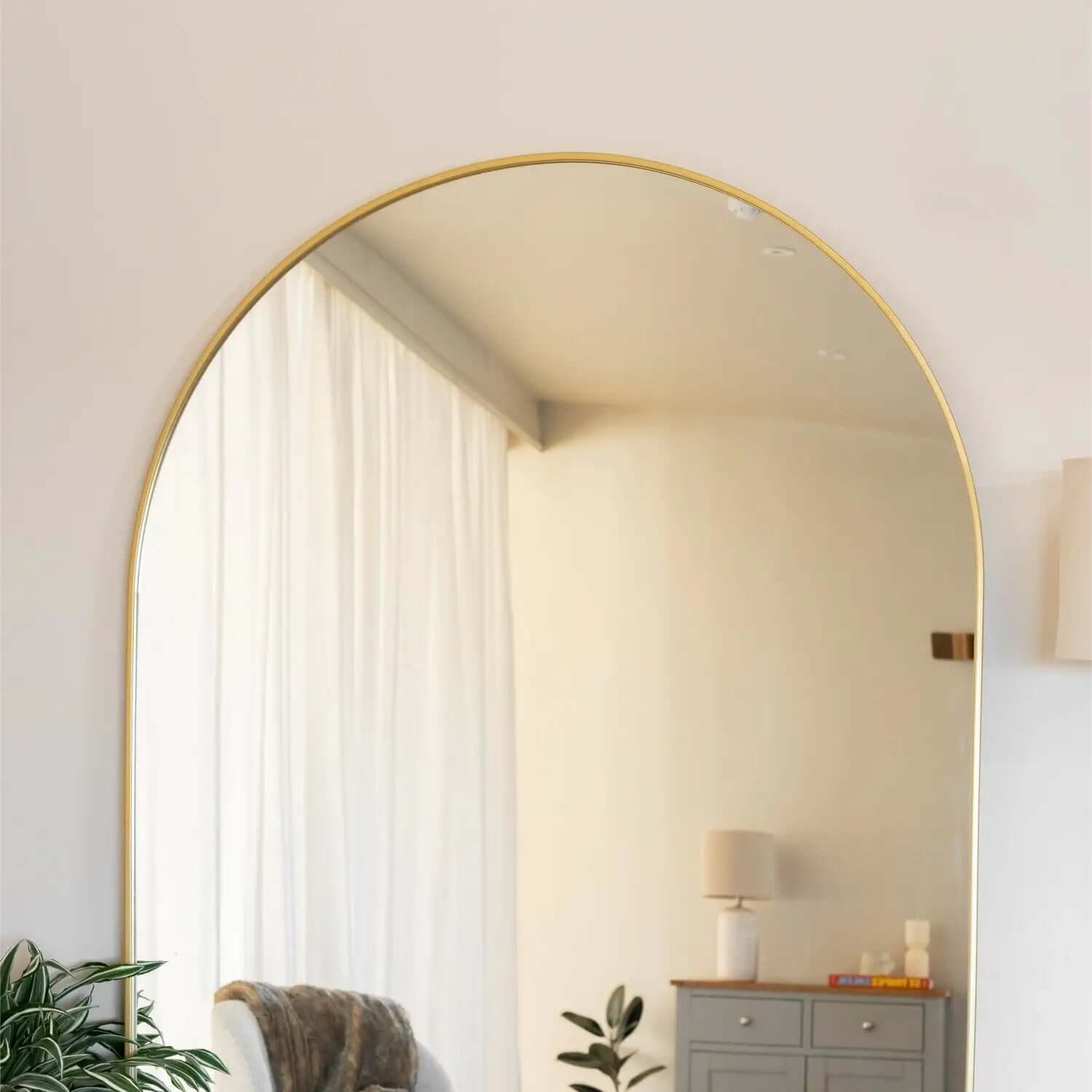 Arched mirror with a thin gold frame.