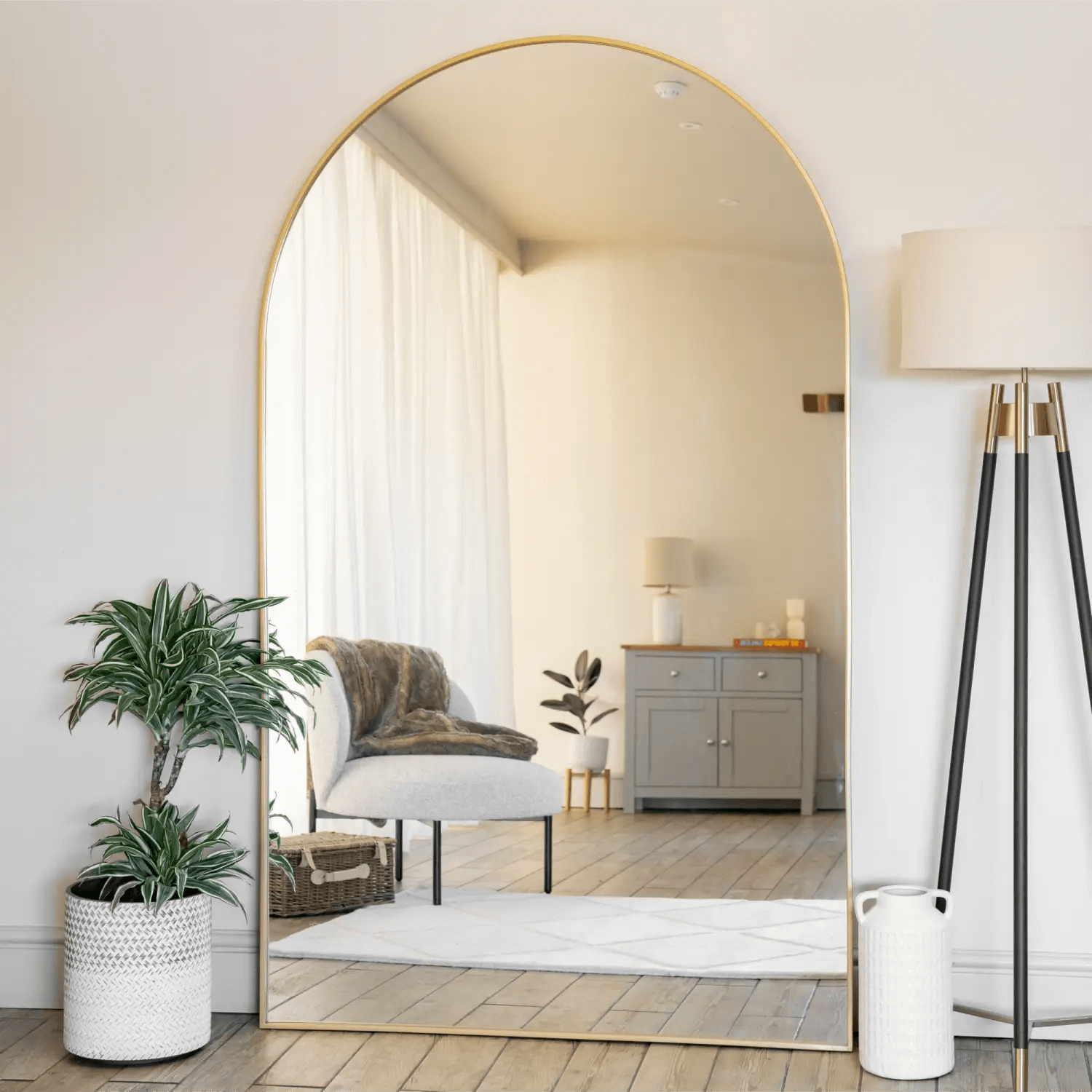 Arched gold-framed floor mirror with a minimalist design.