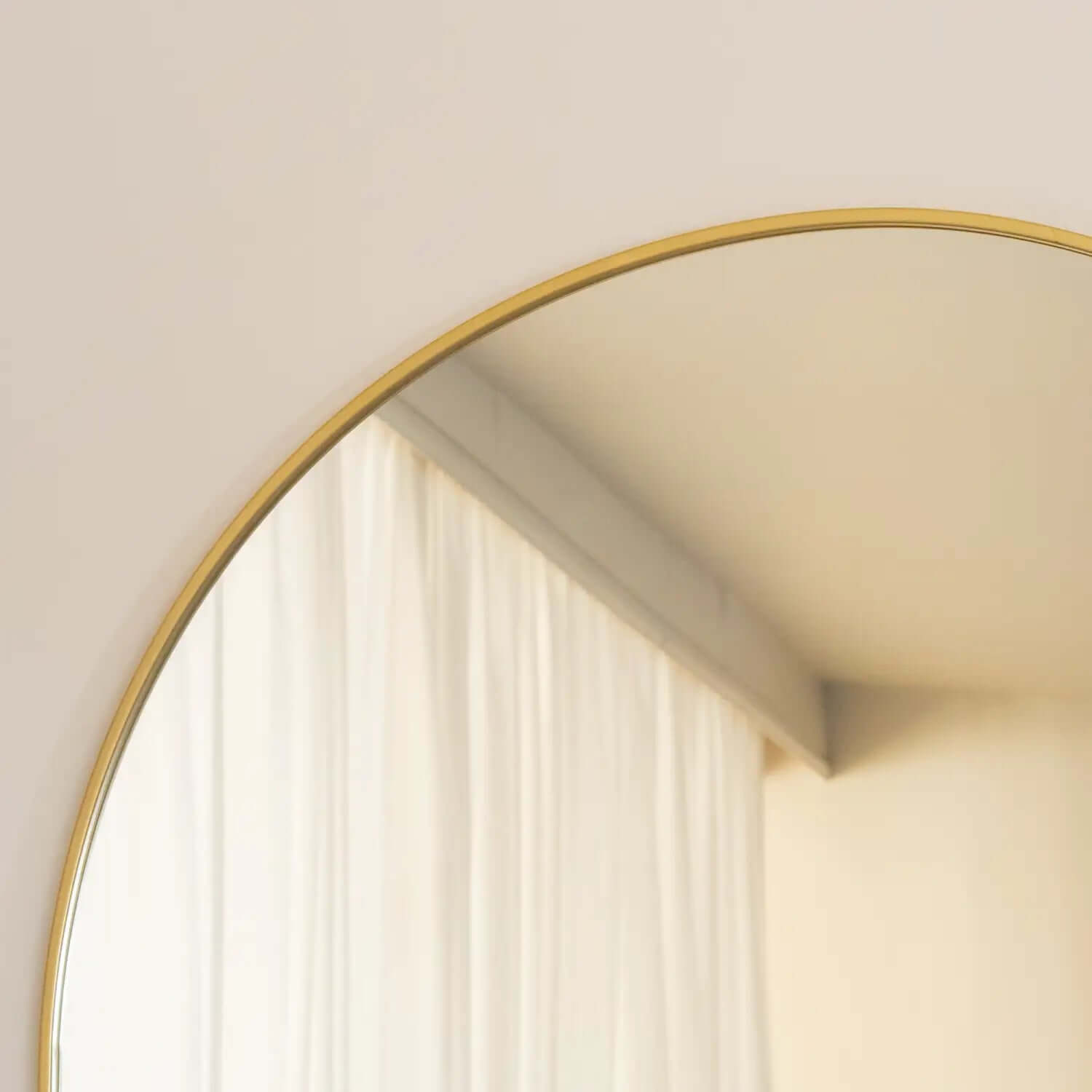 Circular mirror with a thin gold frame.