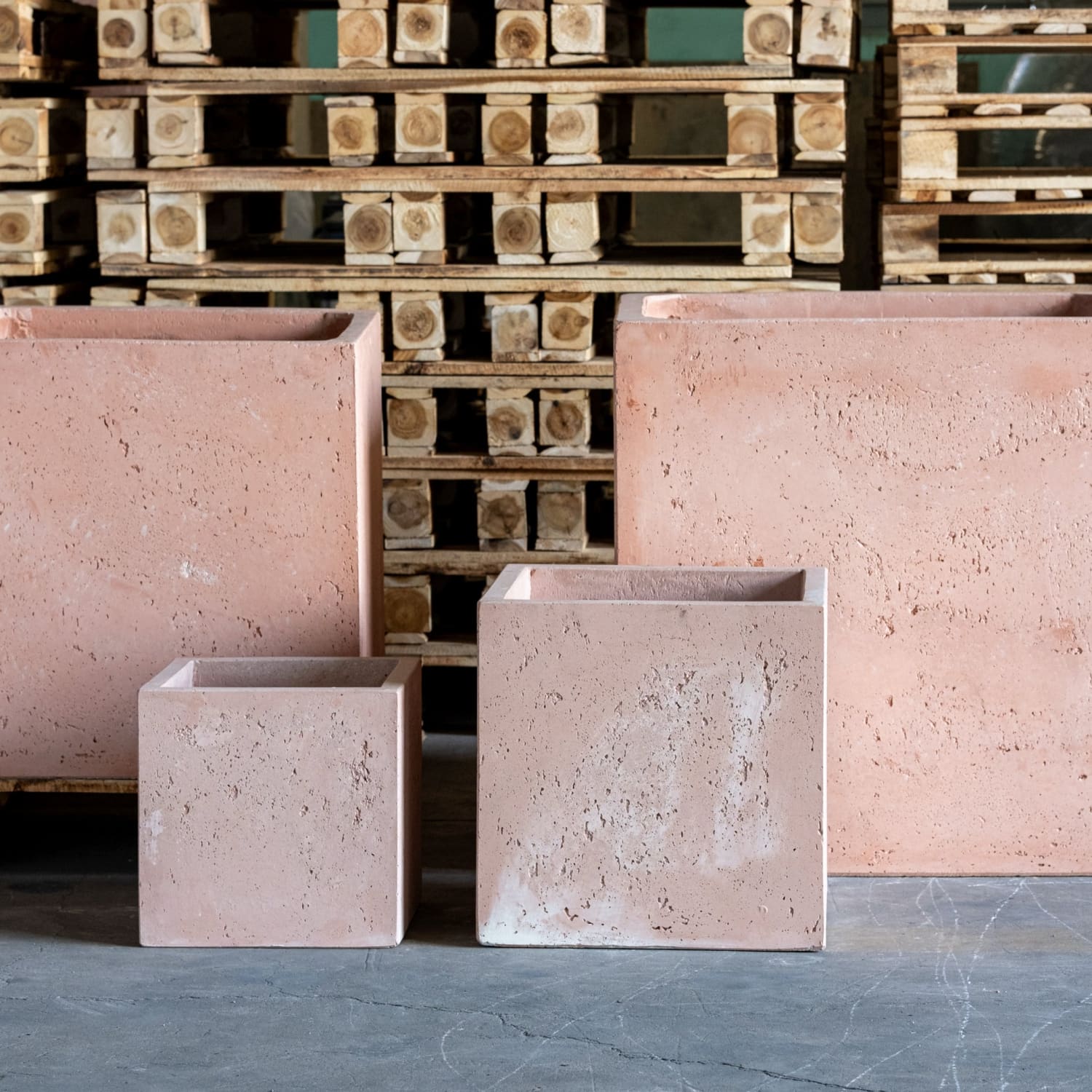 Four pinkish-tan, porous, square planters.