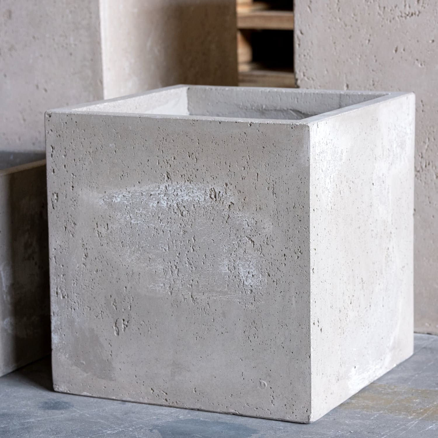 Rough-textured, square concrete planter.