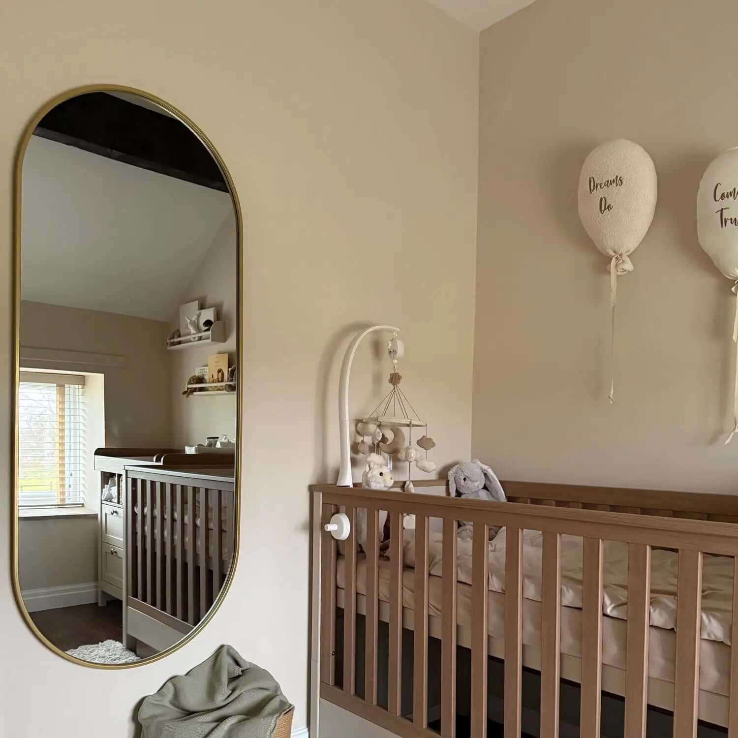 Oval-shaped mirror with a gold metallic frame.