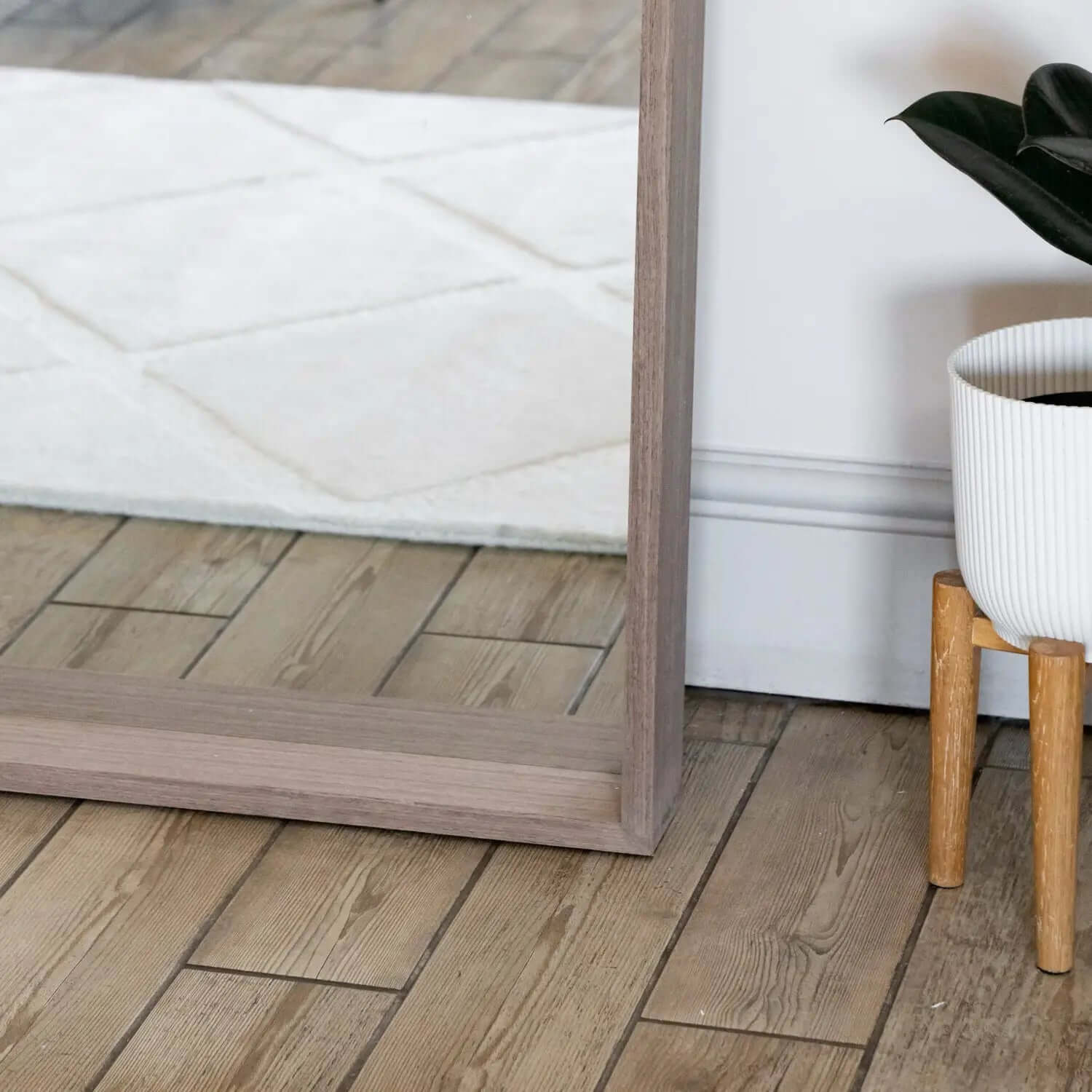 Floor-length mirror with a simple wooden frame.