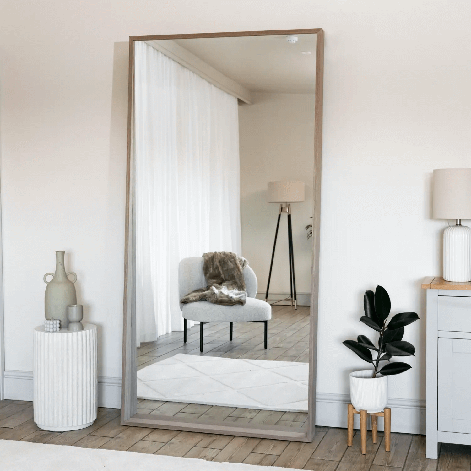 Floor-length mirror with a brown wooden frame.