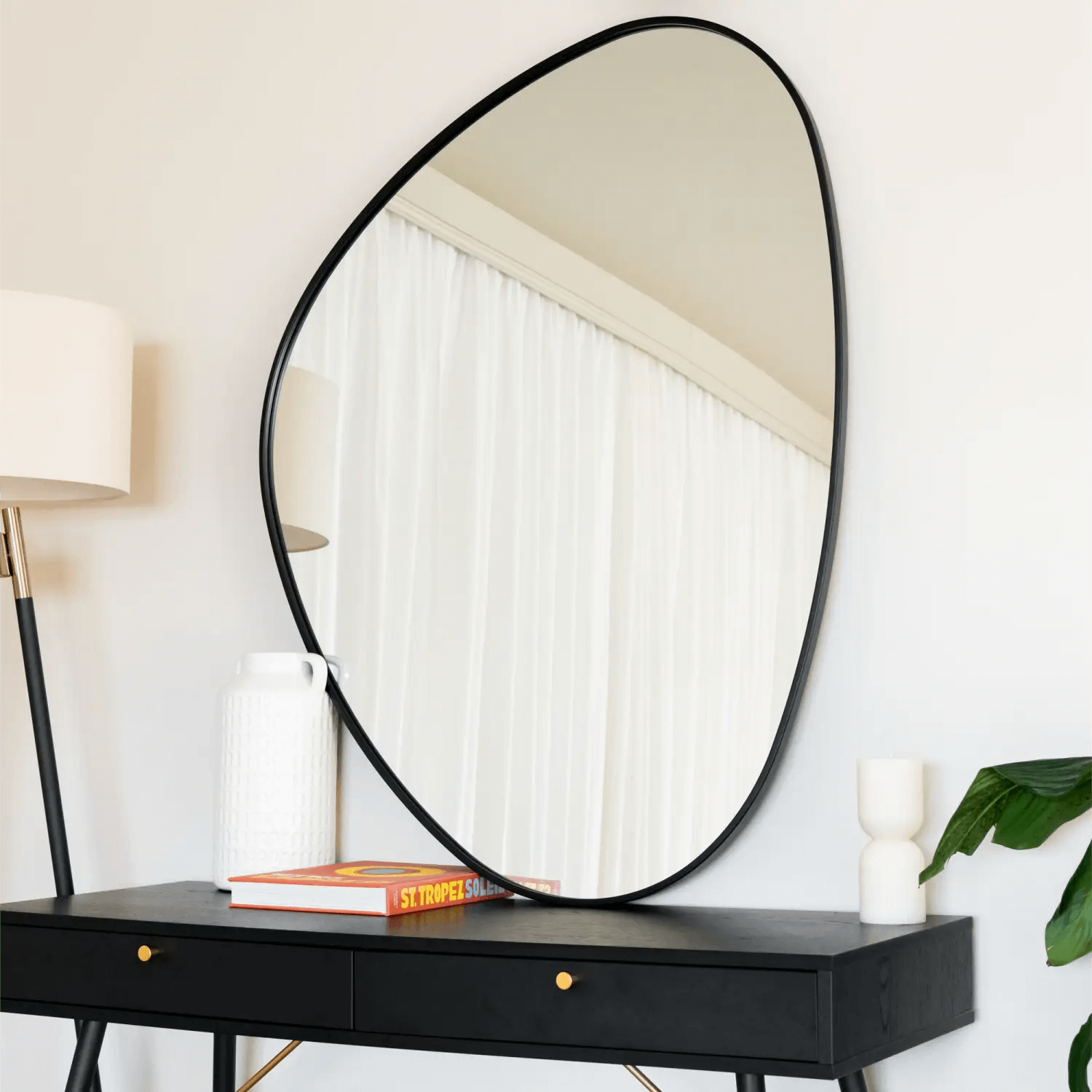 Oval mirror with a thin black metal frame.