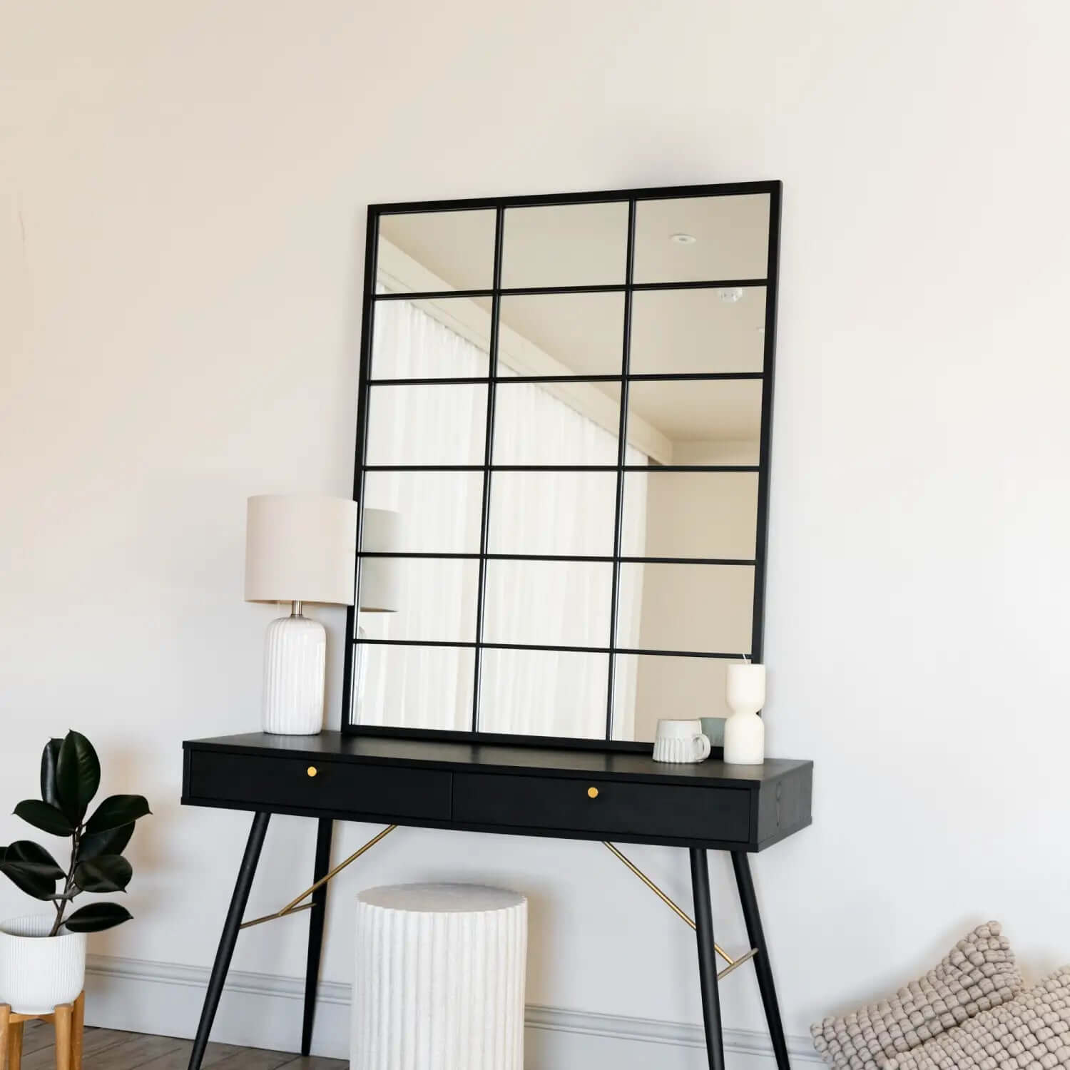 Black-framed grid mirror mounted above a modern console table.