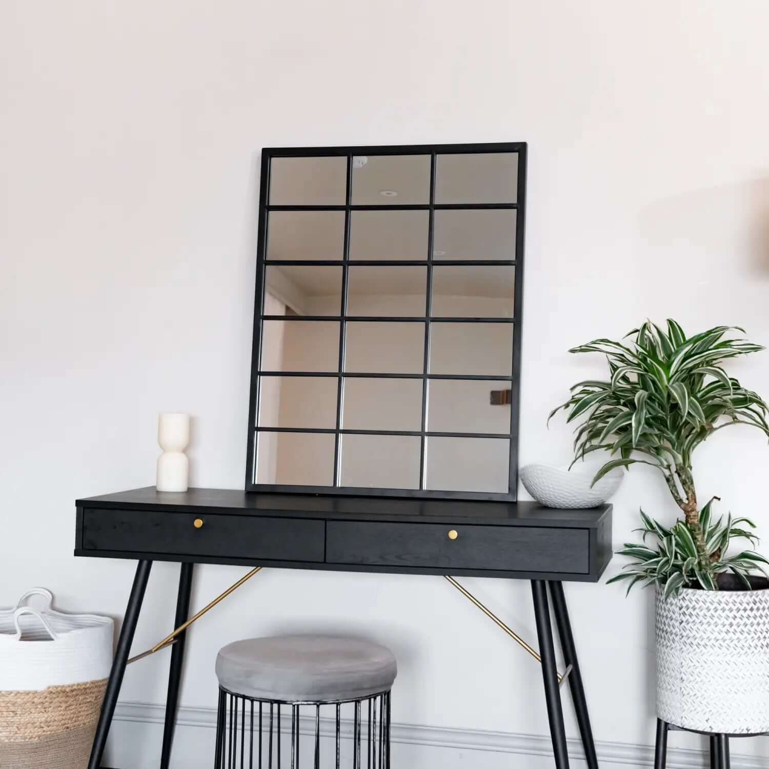 Black console table with two drawers and gold-toned diagonal support bars.