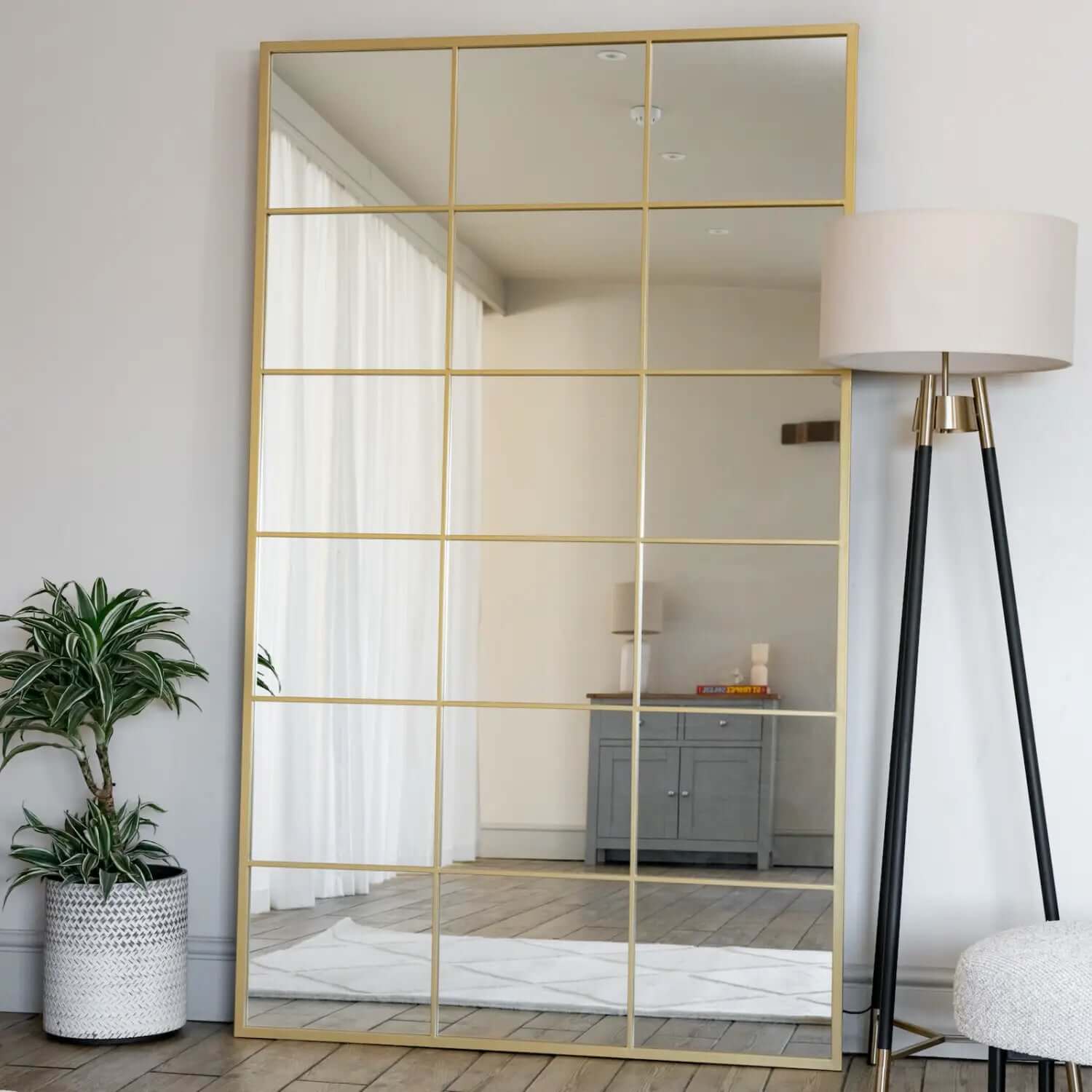 Gold-framed window-pane style mirror with rectangular grid pattern.