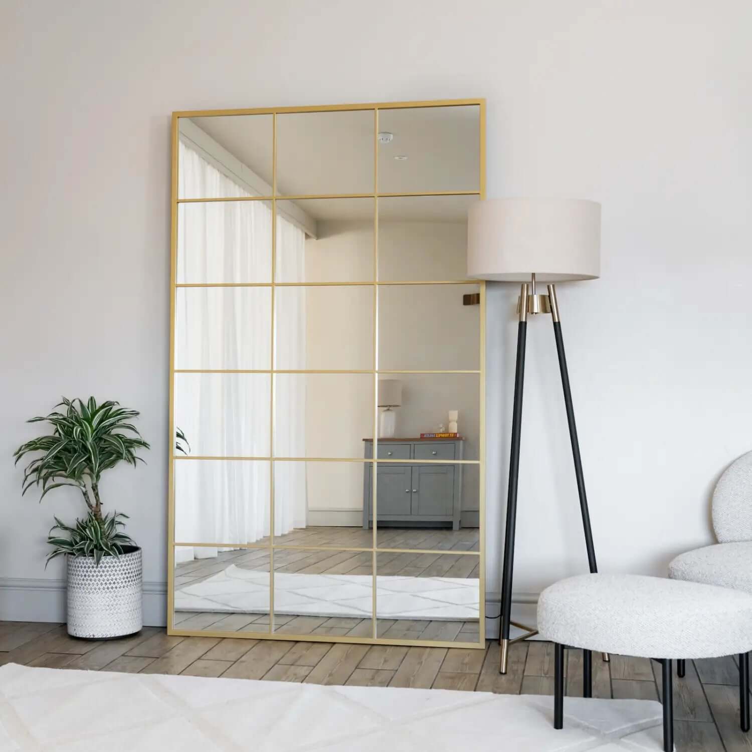 Gold-framed mirror with grid pattern overlay.