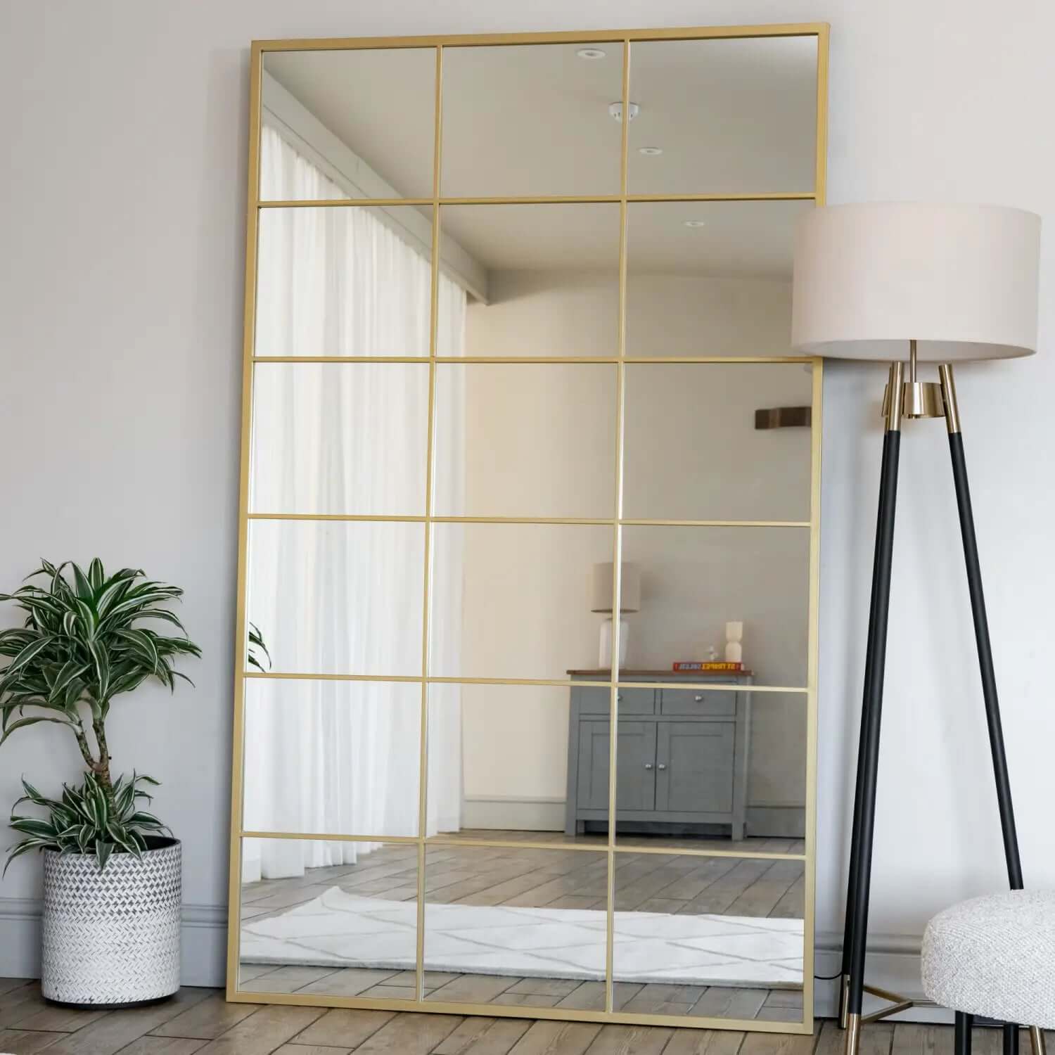 Gold-framed mirror with grid pattern overlay.