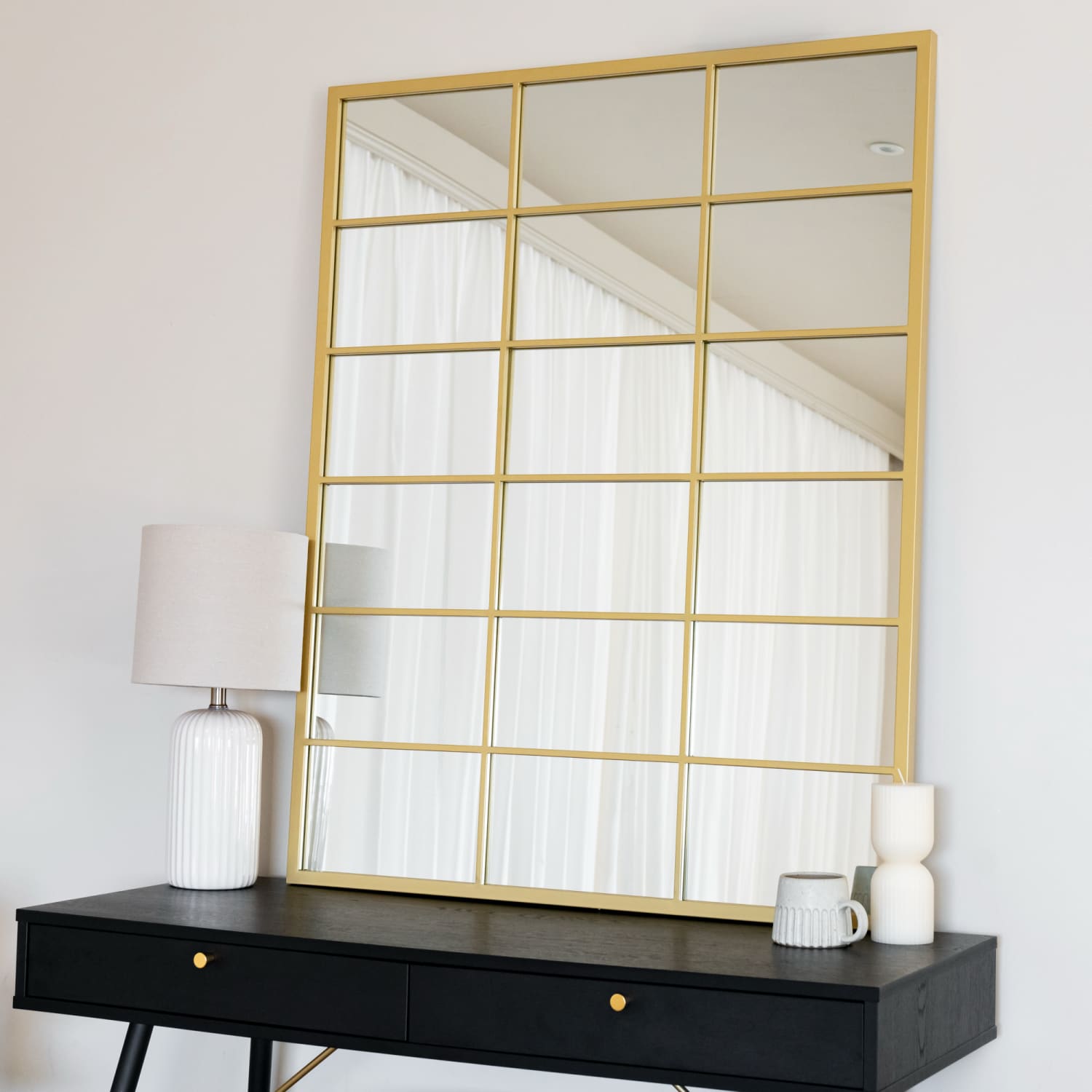 Gold-framed window pane mirror with grid pattern.