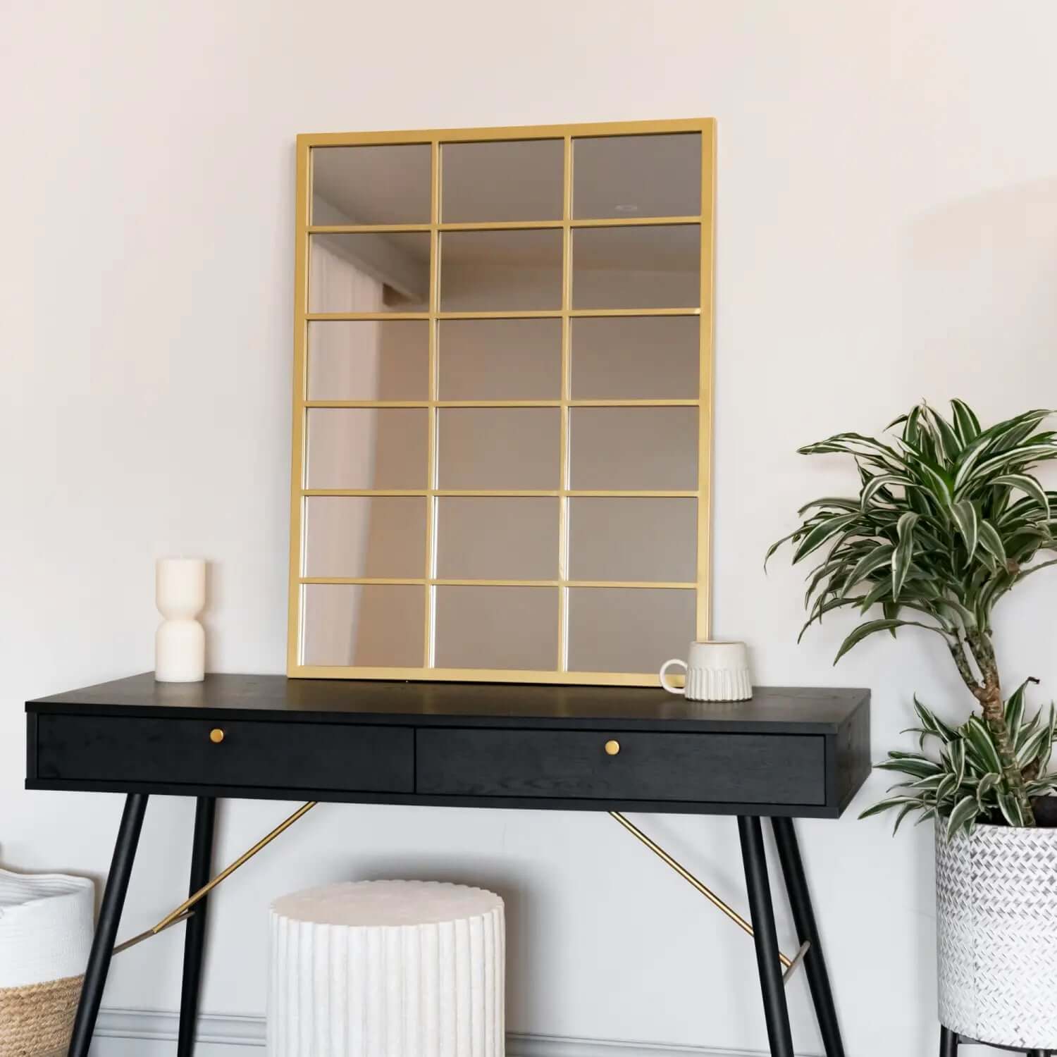 Gold-framed grid mirror with rectangular sections mounted on a wall.