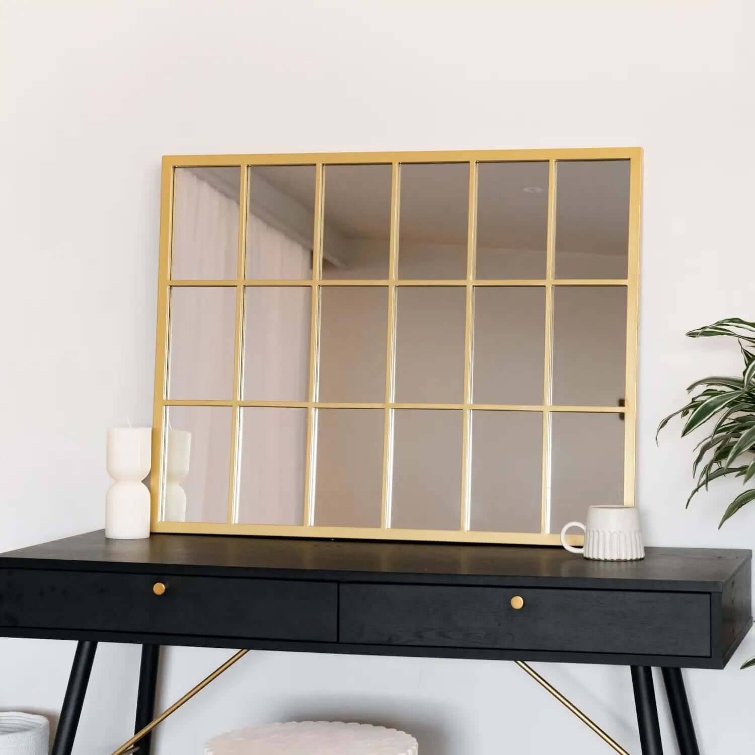 Gold-framed window-pane style mirror with a grid pattern.