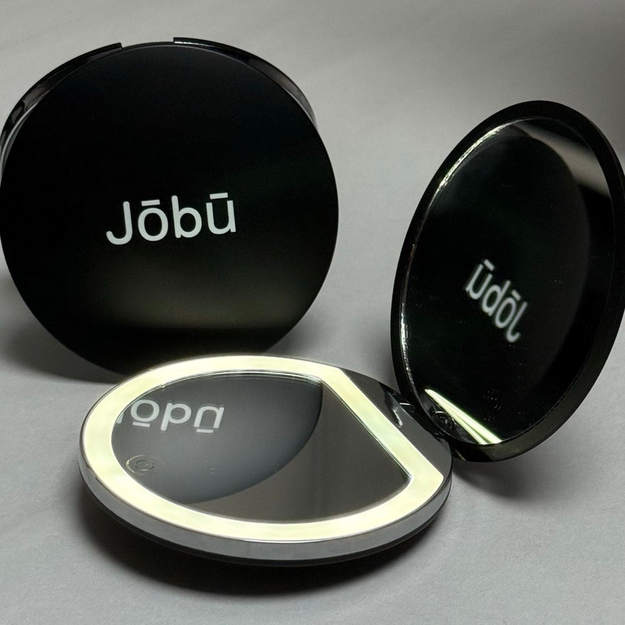 Jobu led travel mirror with black casing and silver accents.