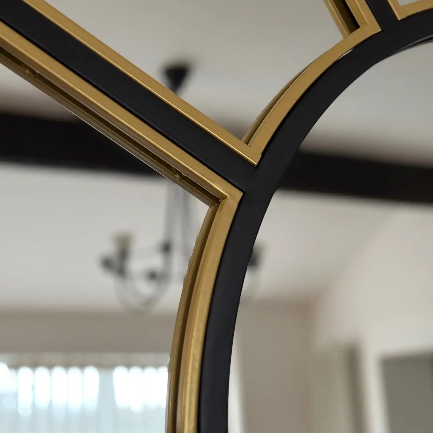 Black and gold decorative mirror frame with curved edges.