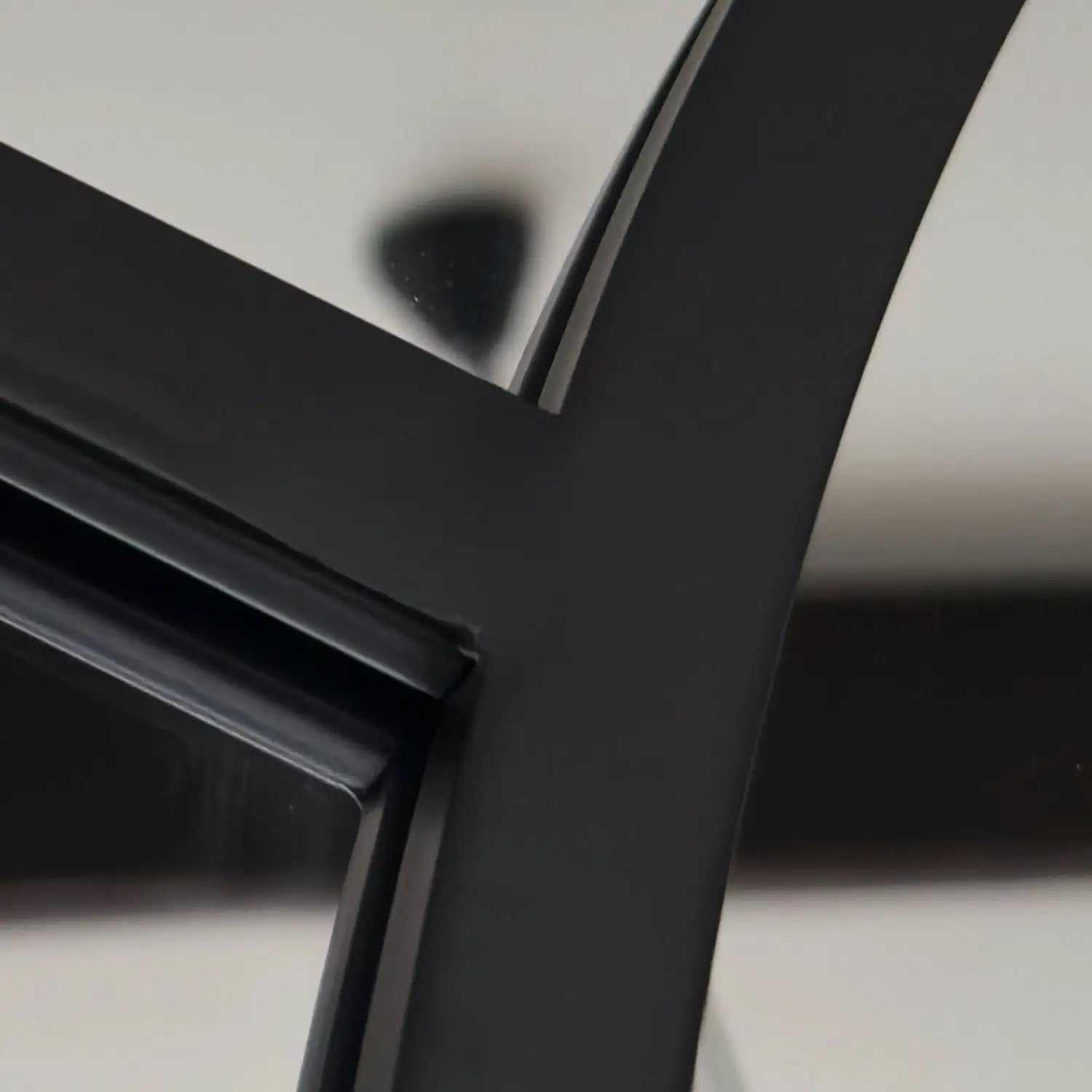 Black metal or plastic structural frame with intersecting angular components.