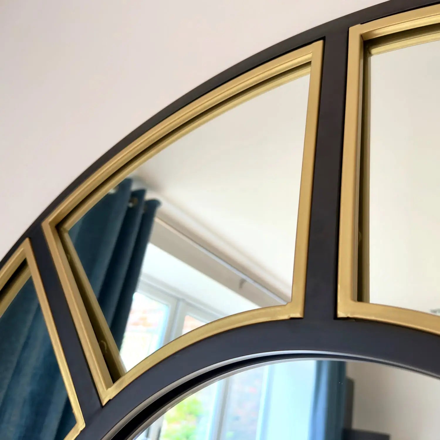 Round mirror with black and gold frame.