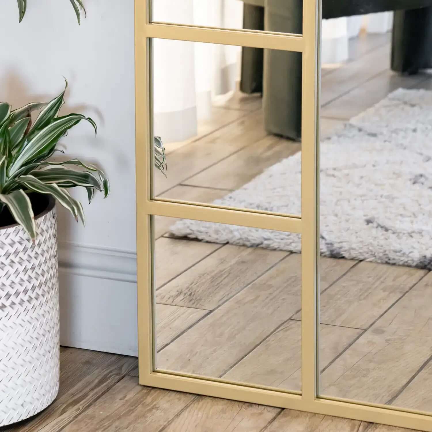 Gold-framed floor mirror with sectioned panels.