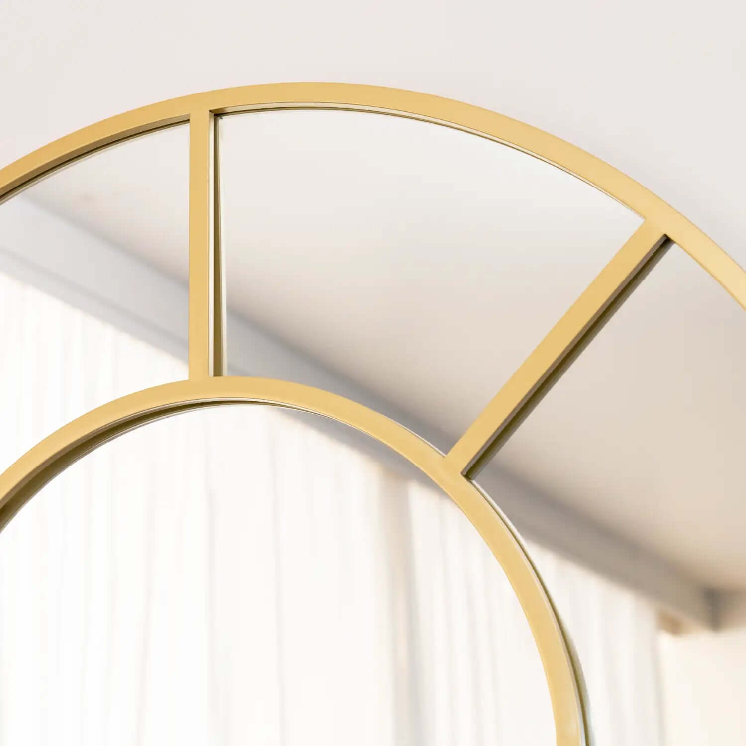 Gold-framed circular mirror with geometric dividing lines.